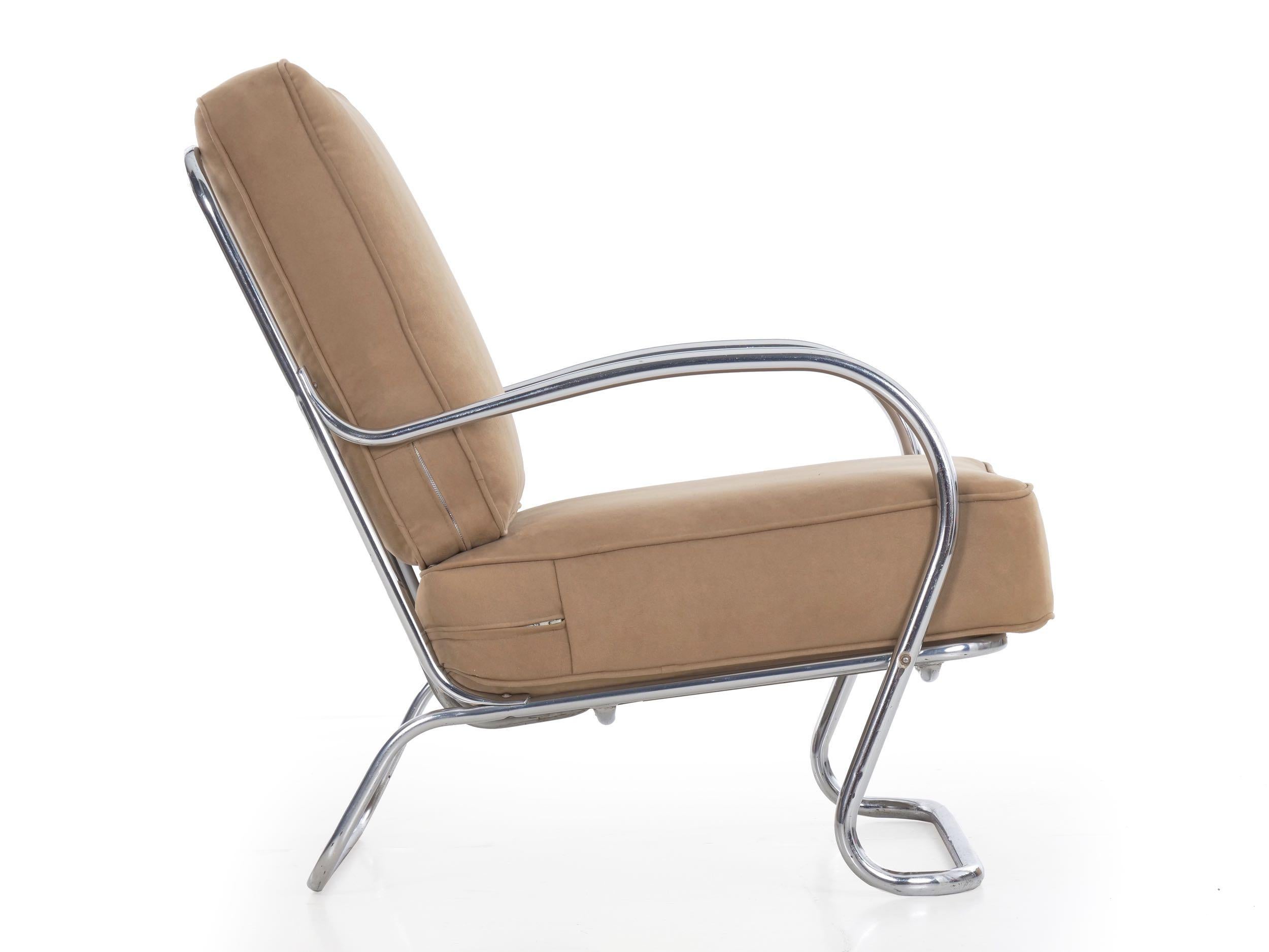 A delightful streamline Moderne lounge chair designed by KEM Weber and manufactured by Lloyd in the 1940s, it is a comfortable and striking seating piece. The beige suede upholstery is warm and deep, an attractive compliment against the strict and