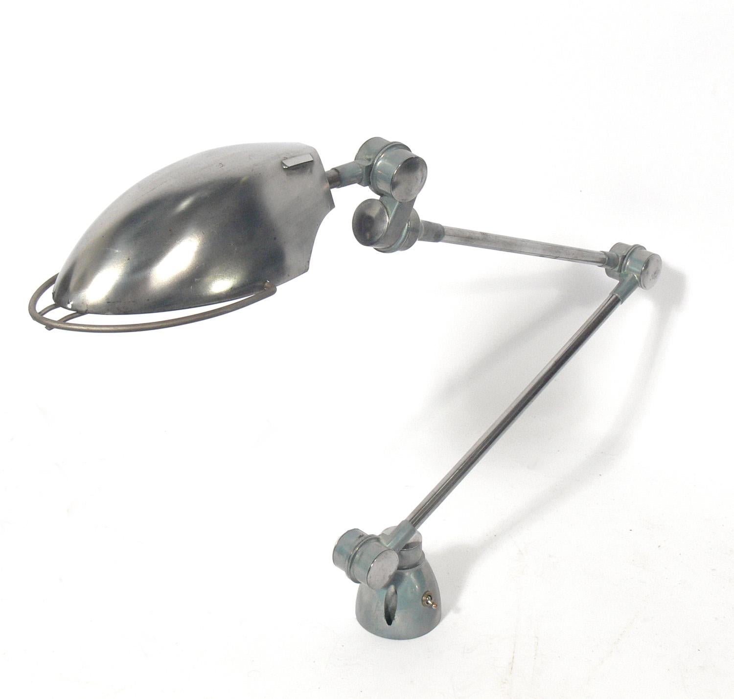 Streamlined metal desk lamp, European, circa 1950s. It has an articulated arm and shade and can be positioned to just the right angle. It has been stripped and has an industrial feel to it. It needs to be mounted with screws onto a desk or table. It