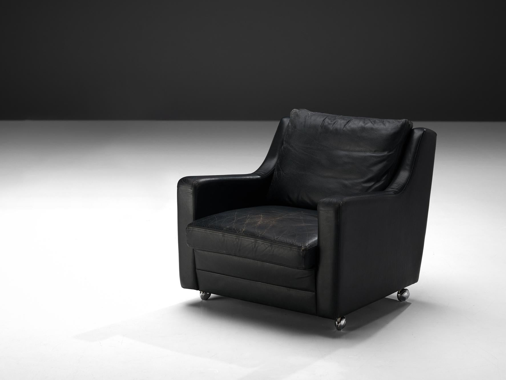 Lounge chair, black leather, metal, Europe, 1970s

This exquisite easy chair showcases a design defined by elegant, clear lines, enhancing their sculptural allure. The backrest seamlessly transitions into the armrests, forming an intriguing sharp