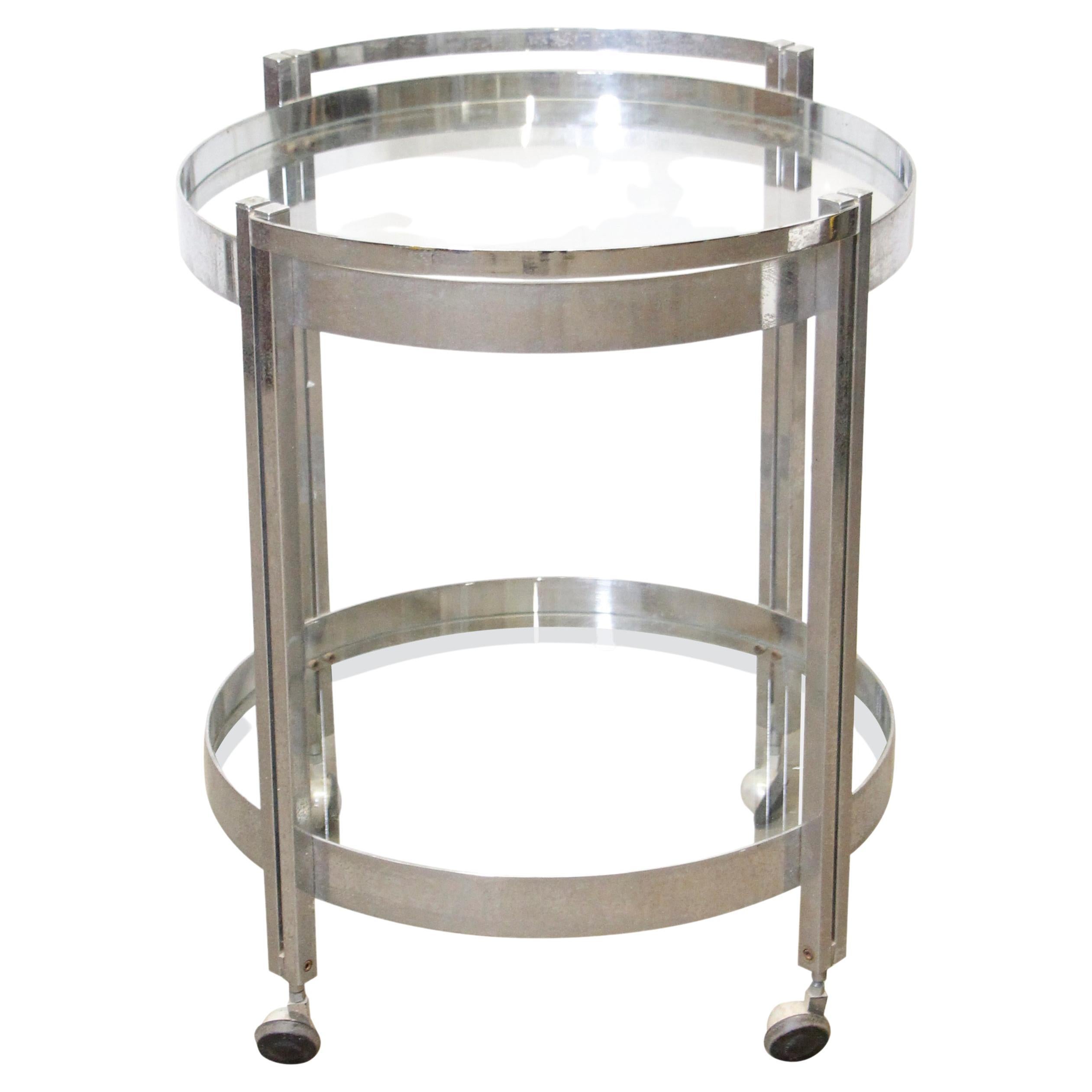 Mid-Century Modern Streamlined bar cart with two-tiered round glass shelves. It is made of polished steel and has wheels for easy accessibility. Imported from Belgium. Please note, this item is located in one of our NYC locations.

