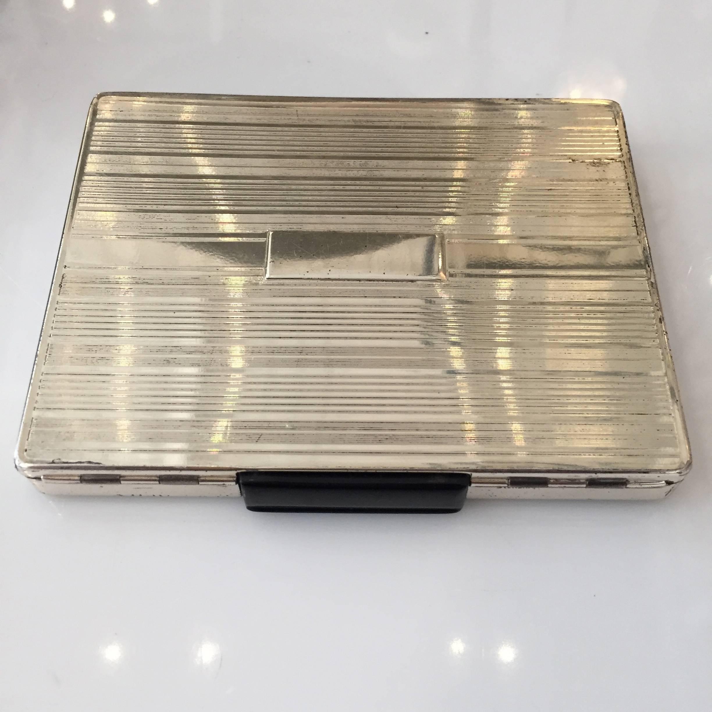 Streamlined sterling silver cigarette case with dispenser, push the black button and a cigarette pops out at you!

Excellent working vintage condition.

Measure: 3 1/4