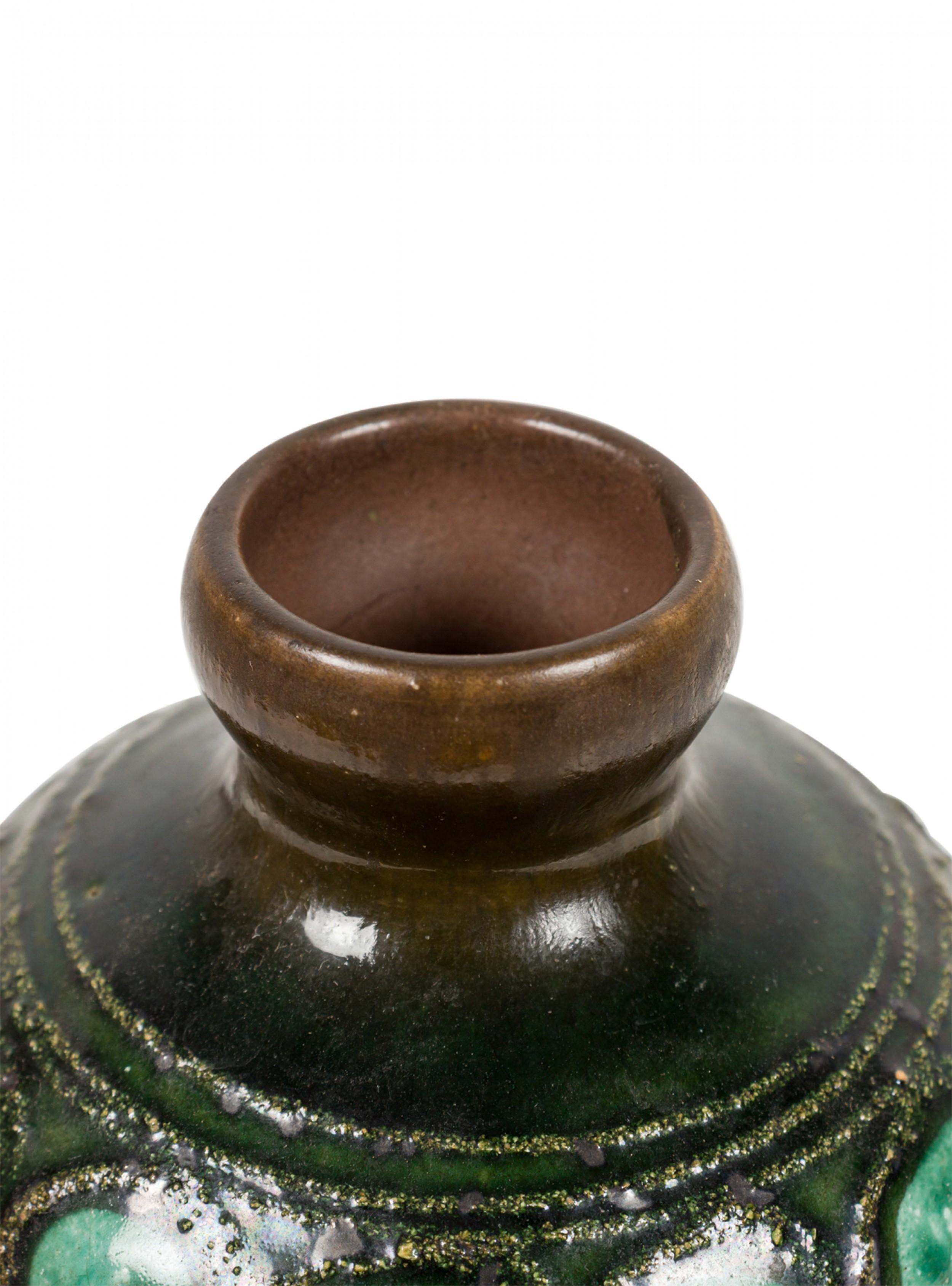 Vase en céramique en forme de bouteille datant du milieu du siècle dernier, originaire d'Allemagne de l'Est. Il présente un double motif de cercles organiques vert clair sur un fond émaillé vert foncé. (marque en bas, STREHLA GDR).
 