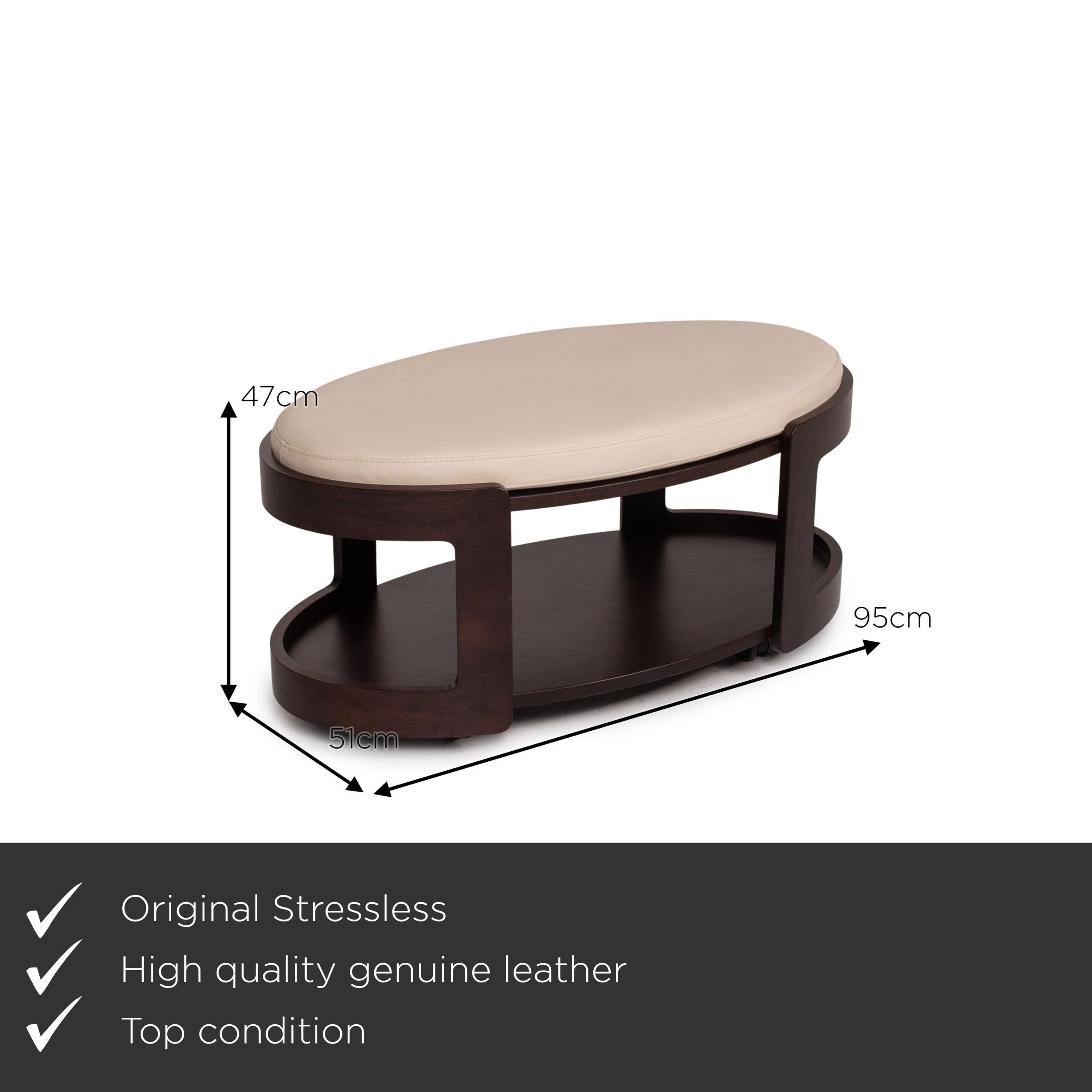 We present to you a Stressless leather wood coffee table dark brown cream table stool.


 Product measurements in centimeters:
 

 Depth 51
 Width 95
 Height 47.





  