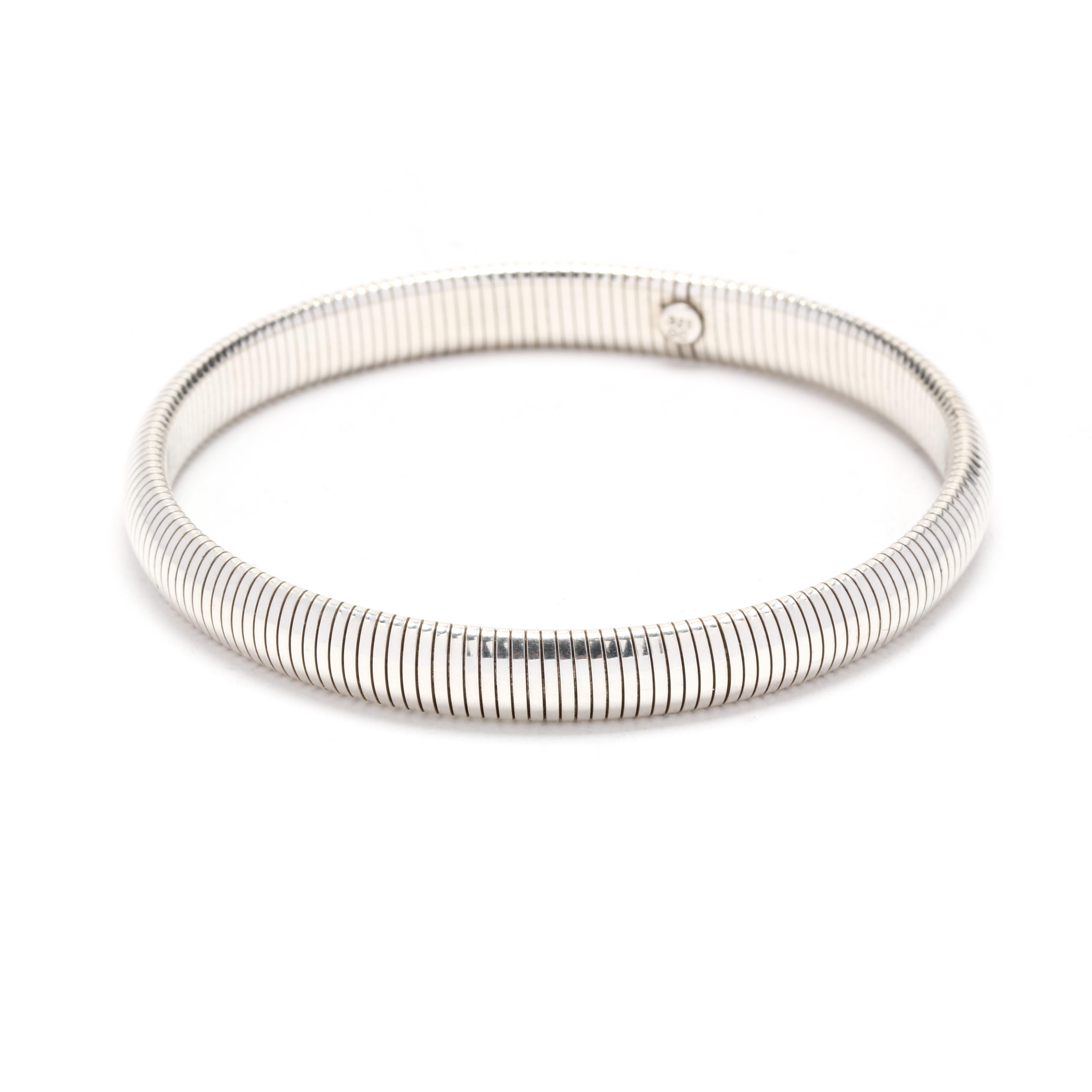A vintage sterling silver stretchy snake bangle bracelet. This simple bracelet features a flexible snake chain in a bangle design.  It is stamped 925 GC.

Length: 7 inches interior circumference

Width: 1/4 inch

Weight: 8.8 dwt / 13.7 grams

Metal: