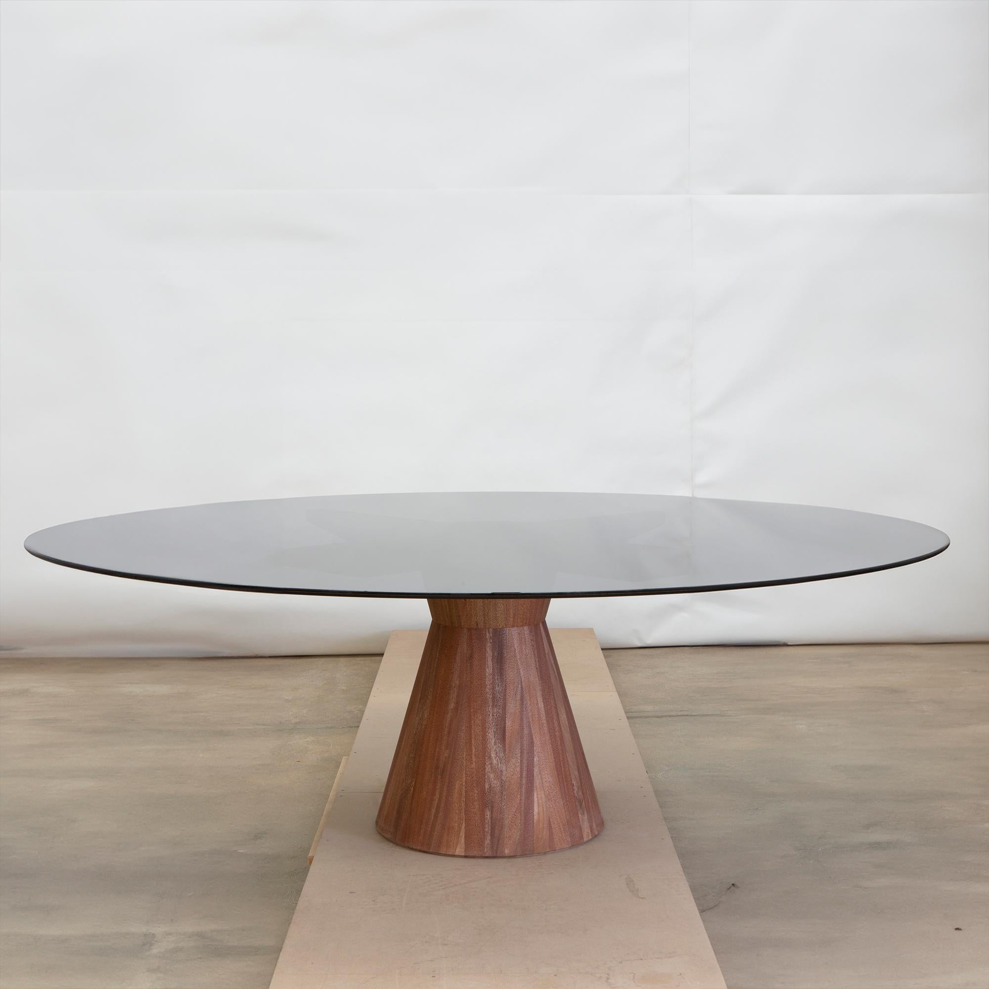 Notre table Affinis présente un design aux lignes simples mais saisissantes, ce qui en fait le choix idéal pour divers environnements, que ce soit à l'intérieur ou à l'extérieur. Fabriquée avec précision, la base en bois massif sert de point