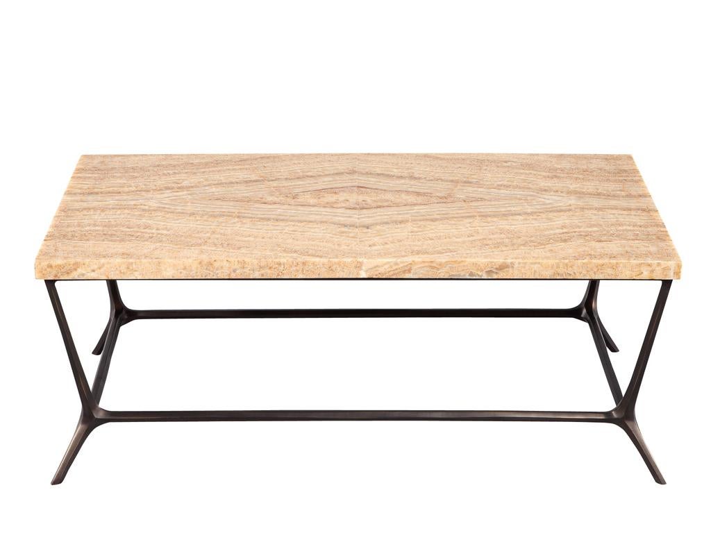 Der Strider Cocktail Table von Ironies ist ein wahres Meisterwerk des Möbeldesigns. Dieses atemberaubende Stück verfügt über einen Sockel aus sandgegossenem Messing in dunkler Bronzeoptik mit komplizierten, behauenen Details, die ihm einen Hauch von