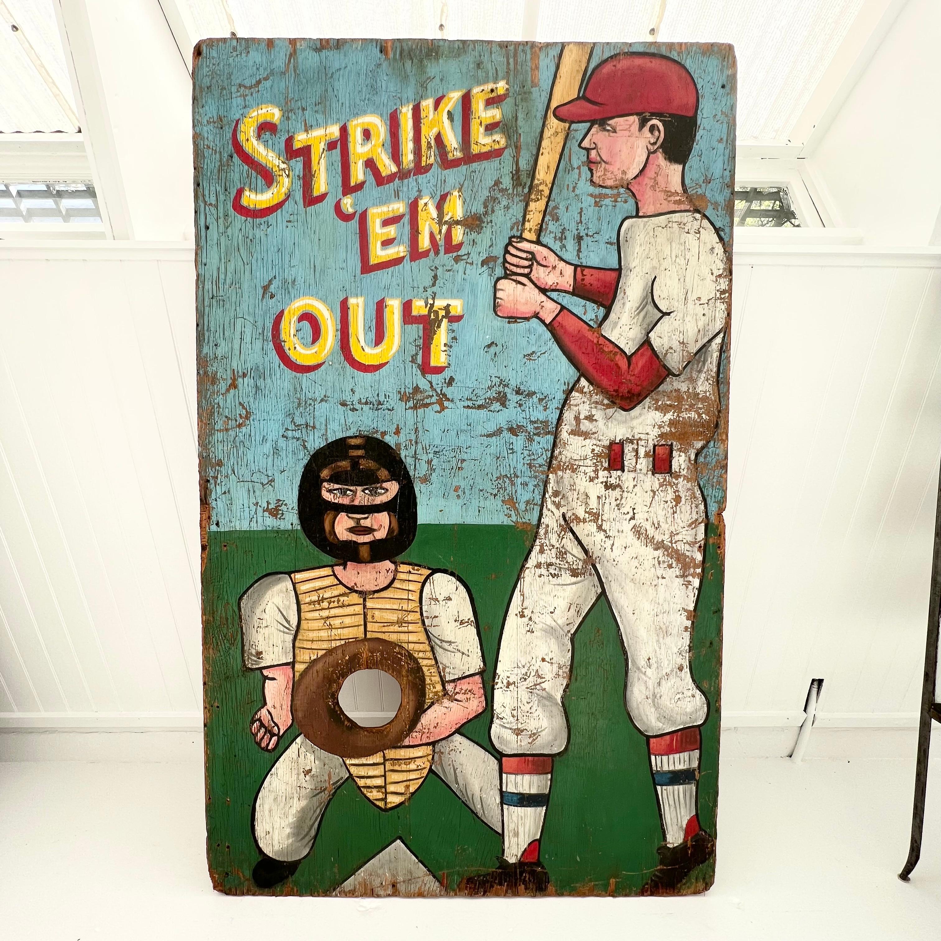 Unique vintage, mid-20th century “Strike ‘Em Out” game sign. 6.5 feet tall and 4 feet wide. Hand painted on 0.75 inch thick plywood. Strike Out originated as a baseball-like street game but also became a popular carnival attraction, where a pitcher
