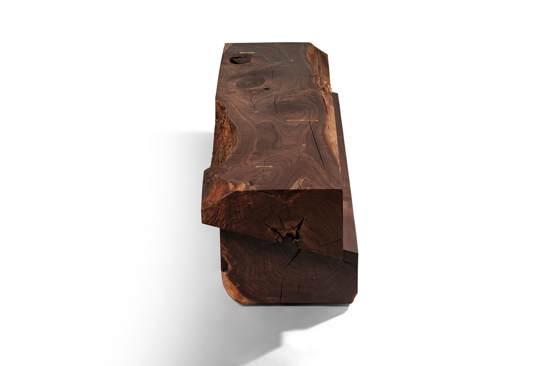 In the largest piece in the Strike/Slip series by Taylor Donsker, a massive block of solid Black Walnut is sawn and then rejoined into a single, shifted beam. Marbled grain and natural edges roll across the surfaces while Taylor's signature polished