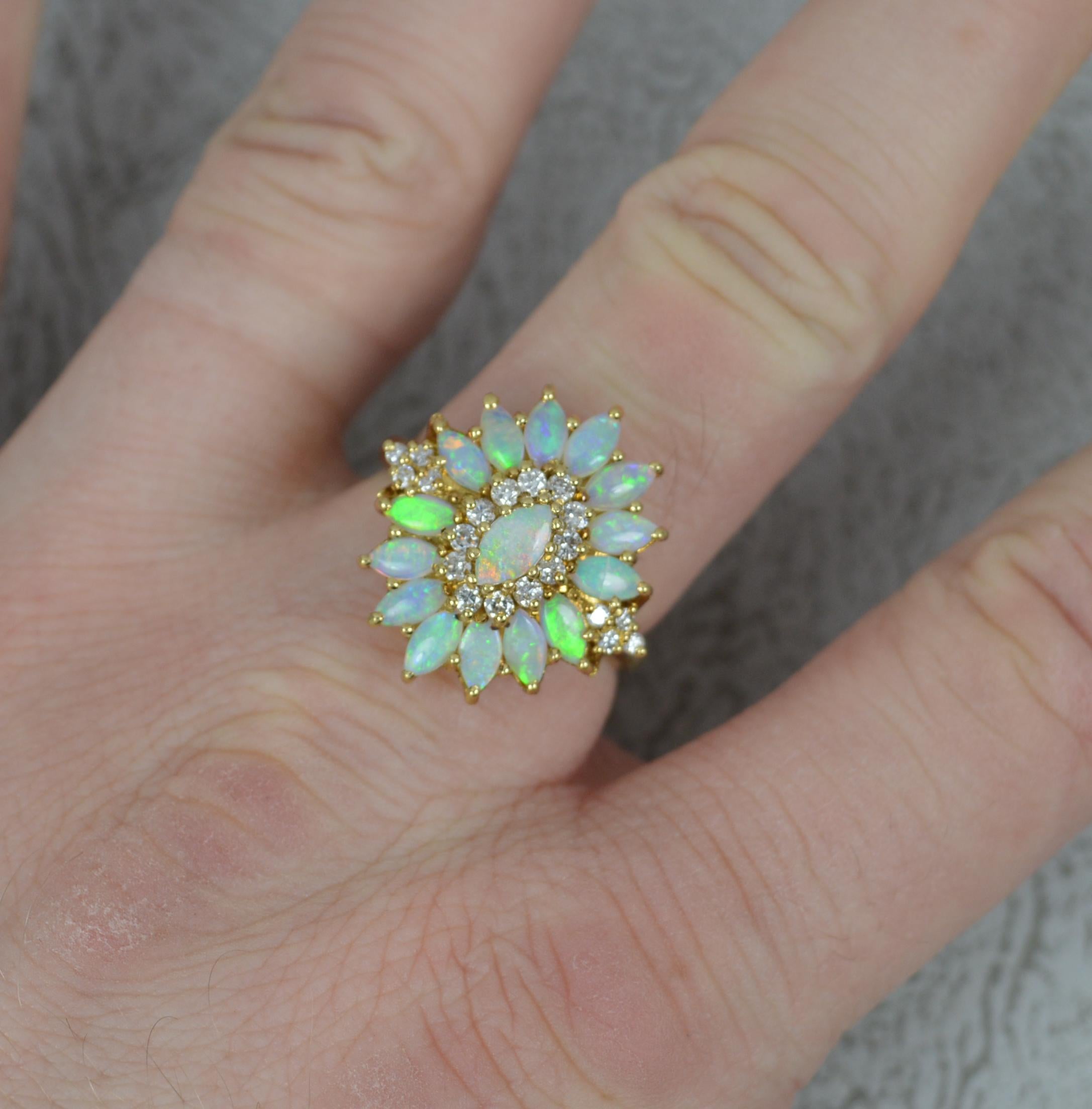 A stunning Opal and Diamond cluster ring.
Solid 18 carat yellow gold.
Set with many natural, marquise shaped opals, each full of colour and well matched. Set with many round brilliant cut diamonds to total 0.3cts. 
19mm x 20mm cluster head.