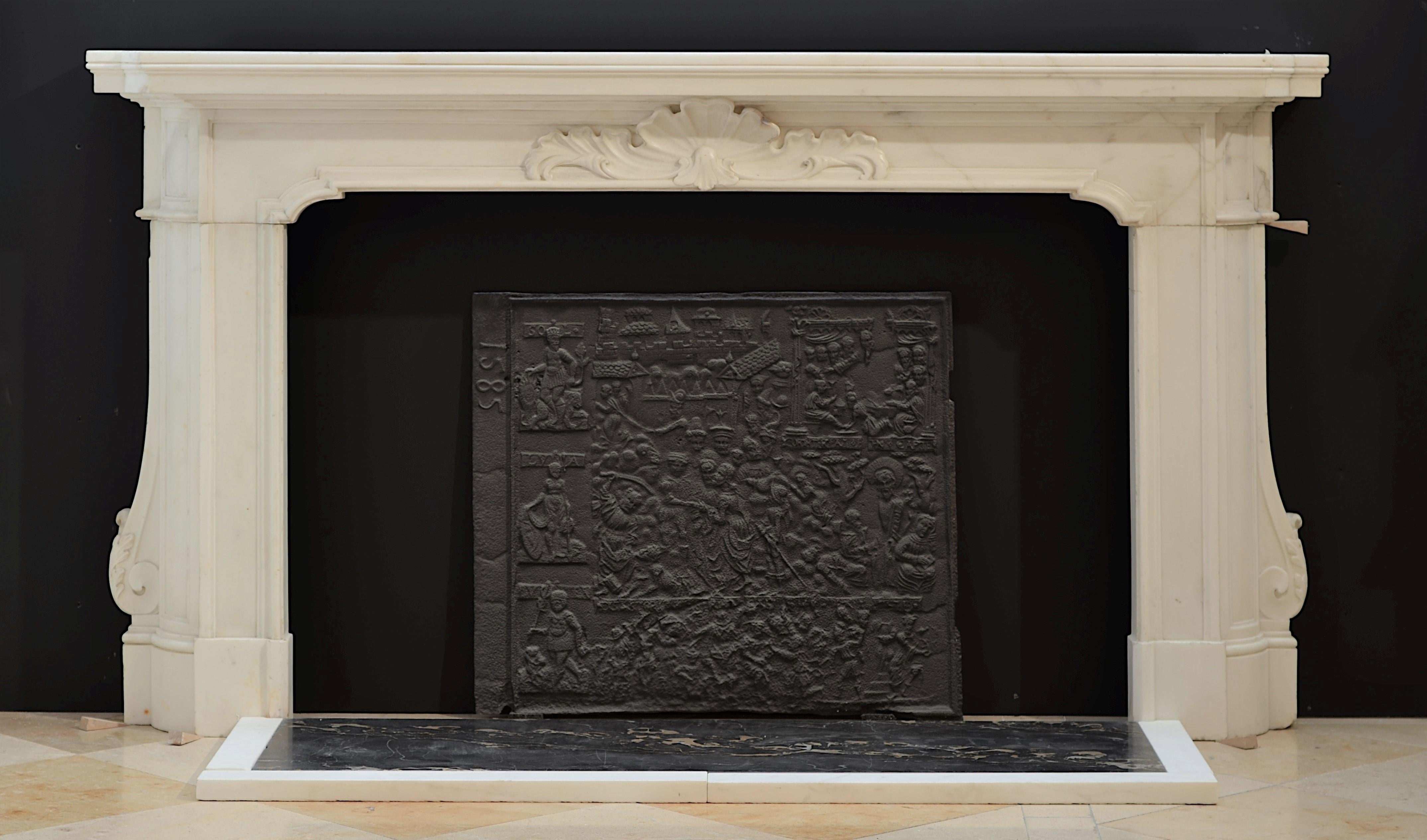 A monumental, 18th century, Italian Baroque fireplace mantel in statuary marble. The frieze, with a beautifully decorated central cartouche, is supported by solid panelled demilune jambs. The floral decorated C- scrolls rest on top of the shaped
