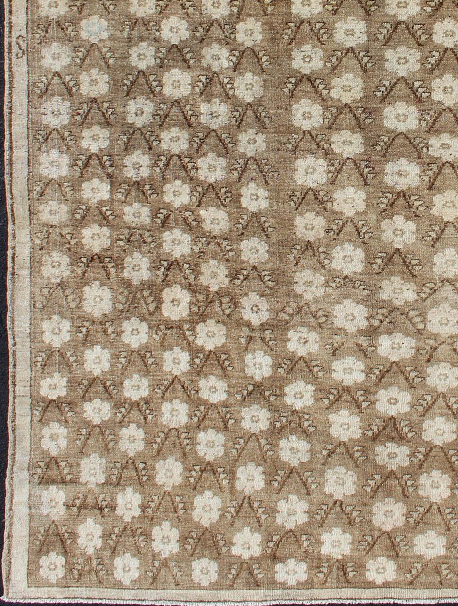 Vintage Oushak rug with all-over pattern in natural tones, rug mtu-95171, country of origin / type: Turkey / Oushak, circa 1940
1940s Turkish Konya rug with flower motifs in brown and cream
This striking Turkish rug features a brown background with