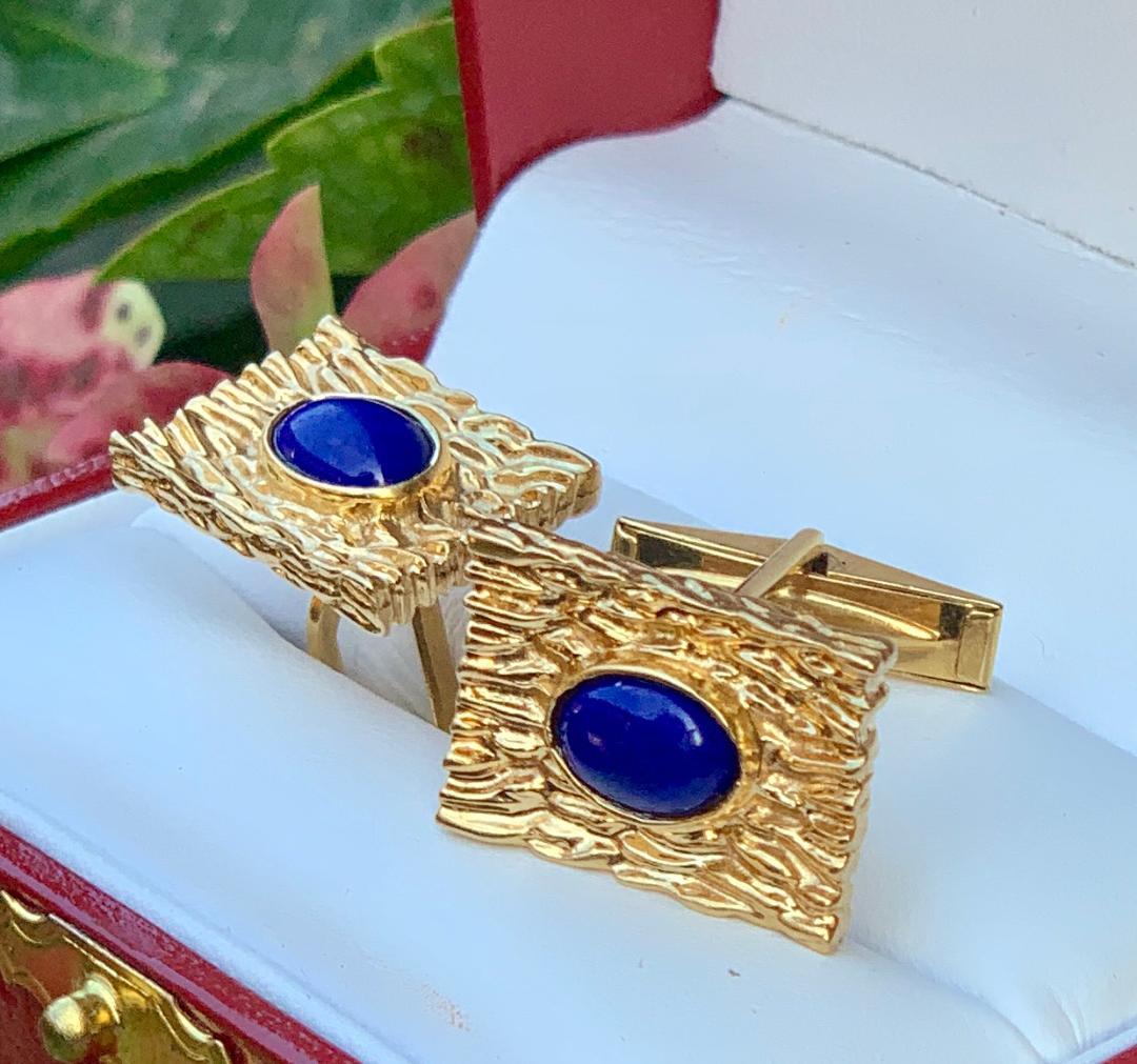 Striking pair of custom hand made mid century estate cufflinks are rectangular in shape and are made out of 14 Karat yellow gold. The richly textured bark finish beautifully compliments the bezel set oval shaped vivid blue lapis lazuli cabochons