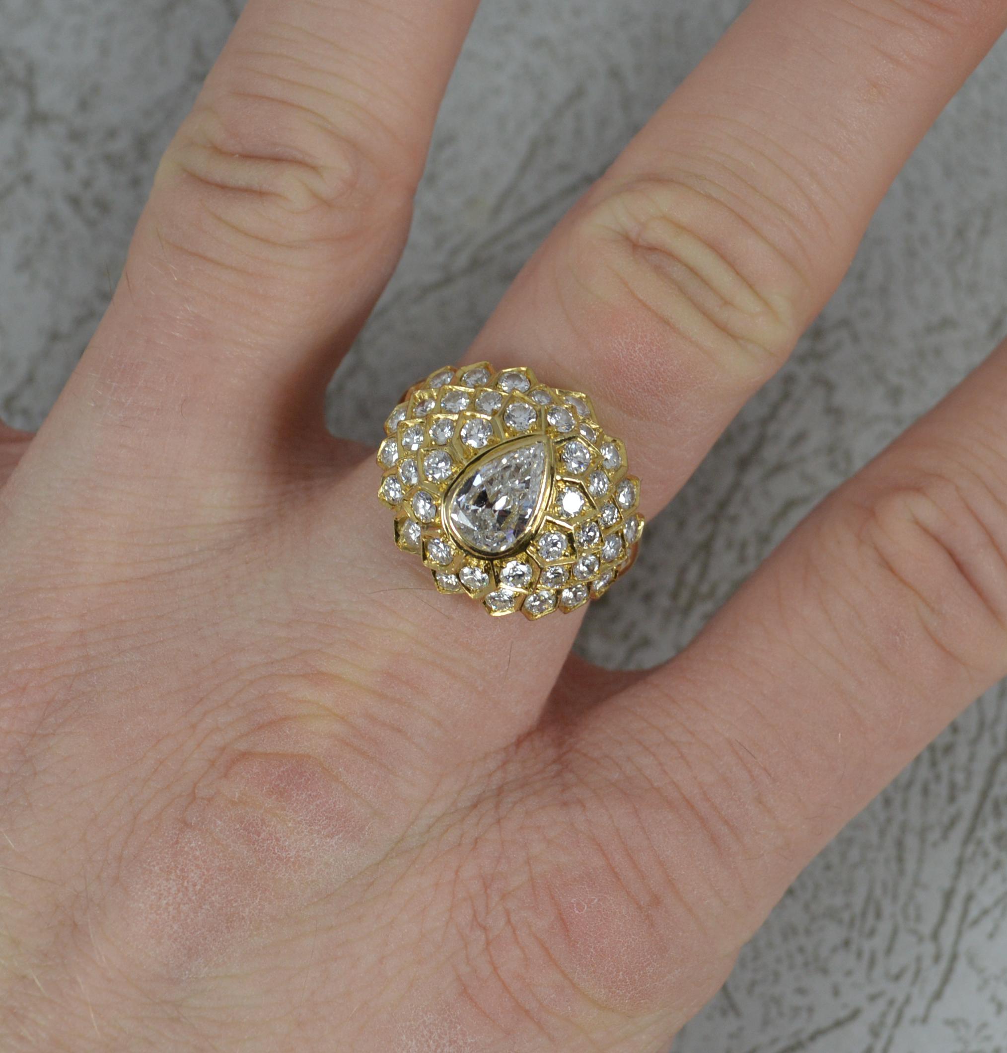 A superb 18ct gold and diamond ring.
18 carat yellow gold shank and setting.
Designed with a large pear cut diamond to centre in full bezel setting. Approx 1.00 full carat. Very clean, bright and sparkly. Surrounding are many smaller round brilliant