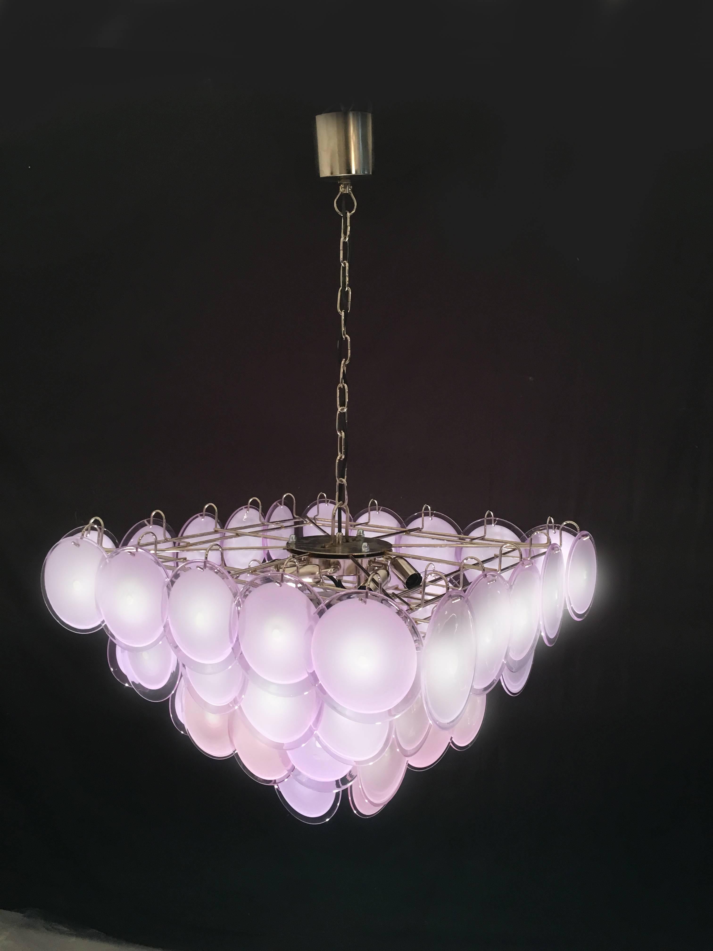 Le lustre est composé de 52 disques en verre précieux de Murano de couleur rose ou améthyste, disposés sur quatre niveaux.
Neuf lampes E14.
Disponible quatre lustres.