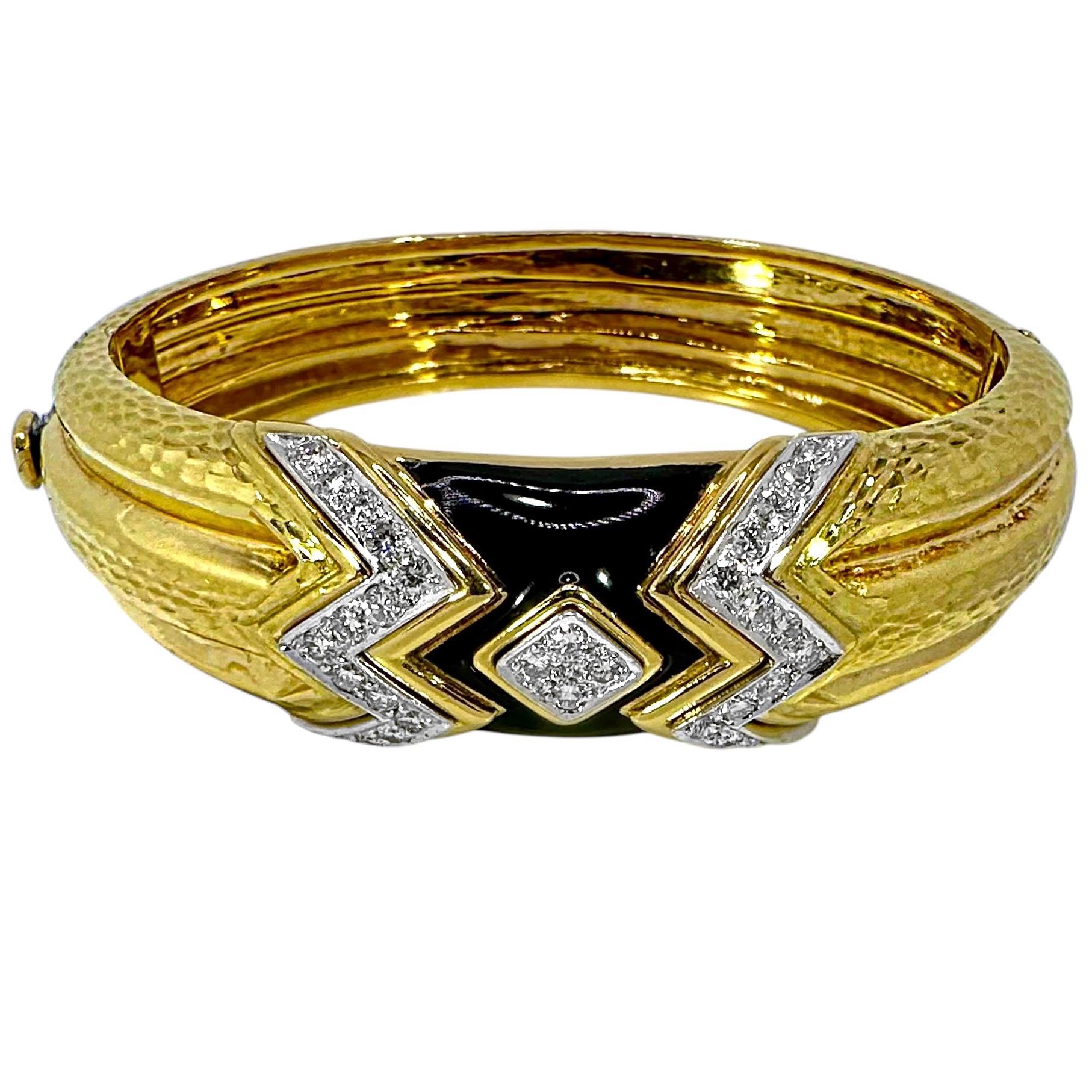 Questo affascinante braccialetto bombe, martellato, in oro giallo 18 carati di Andrew Clunn, presenta un'area di design ricca di linee geometriche di diamanti di alta qualità che contrastano con un campo di smalto nero brillante. Dal pannello