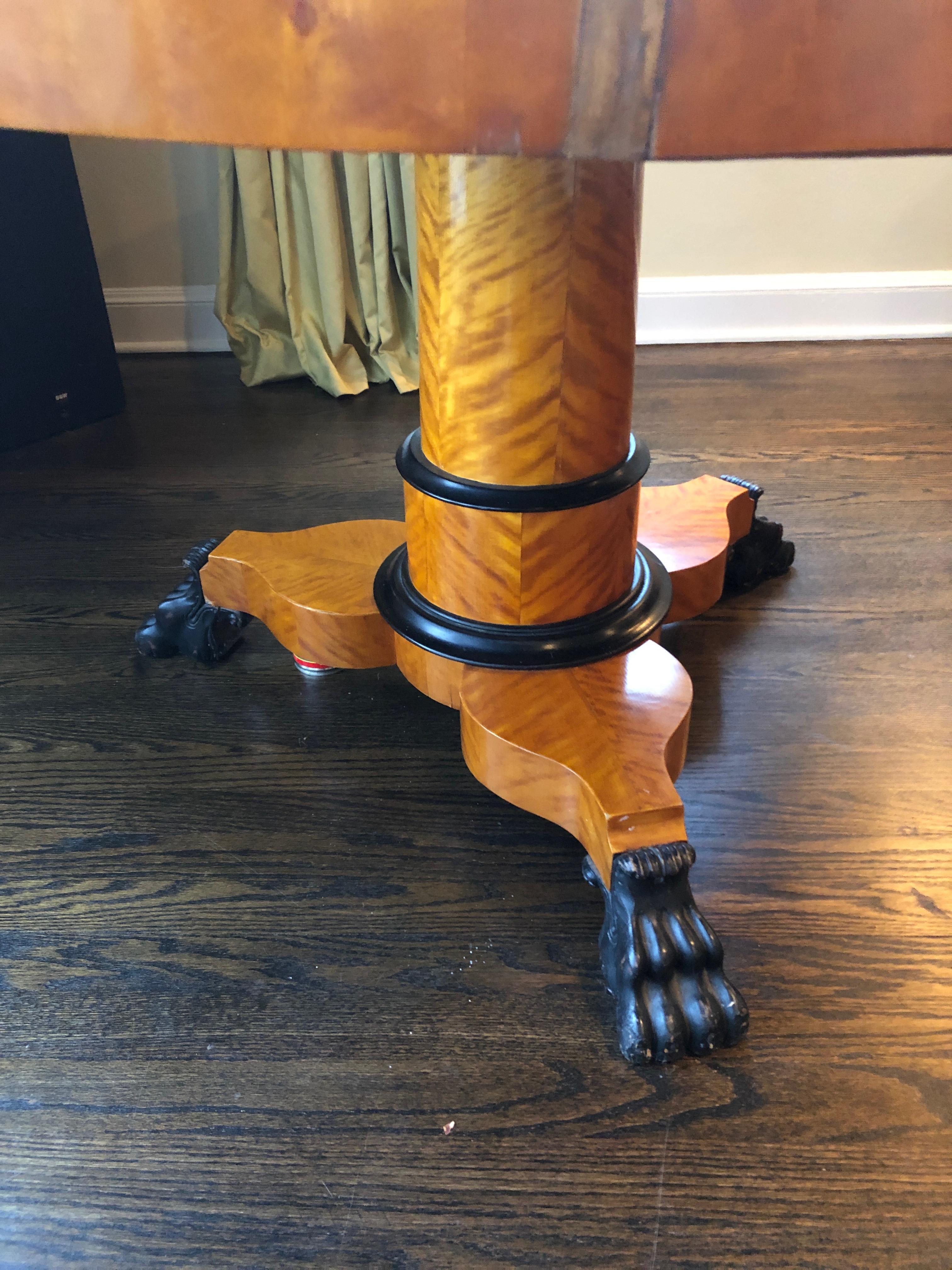 Classic 19th century Biedermeier bird's-eye maple round center or side table having gorgeous grain on the single pedestal, ebonized rings around it and fabulous imposing paw feet on tripod base.
Apron 24.75 H from floor.
         