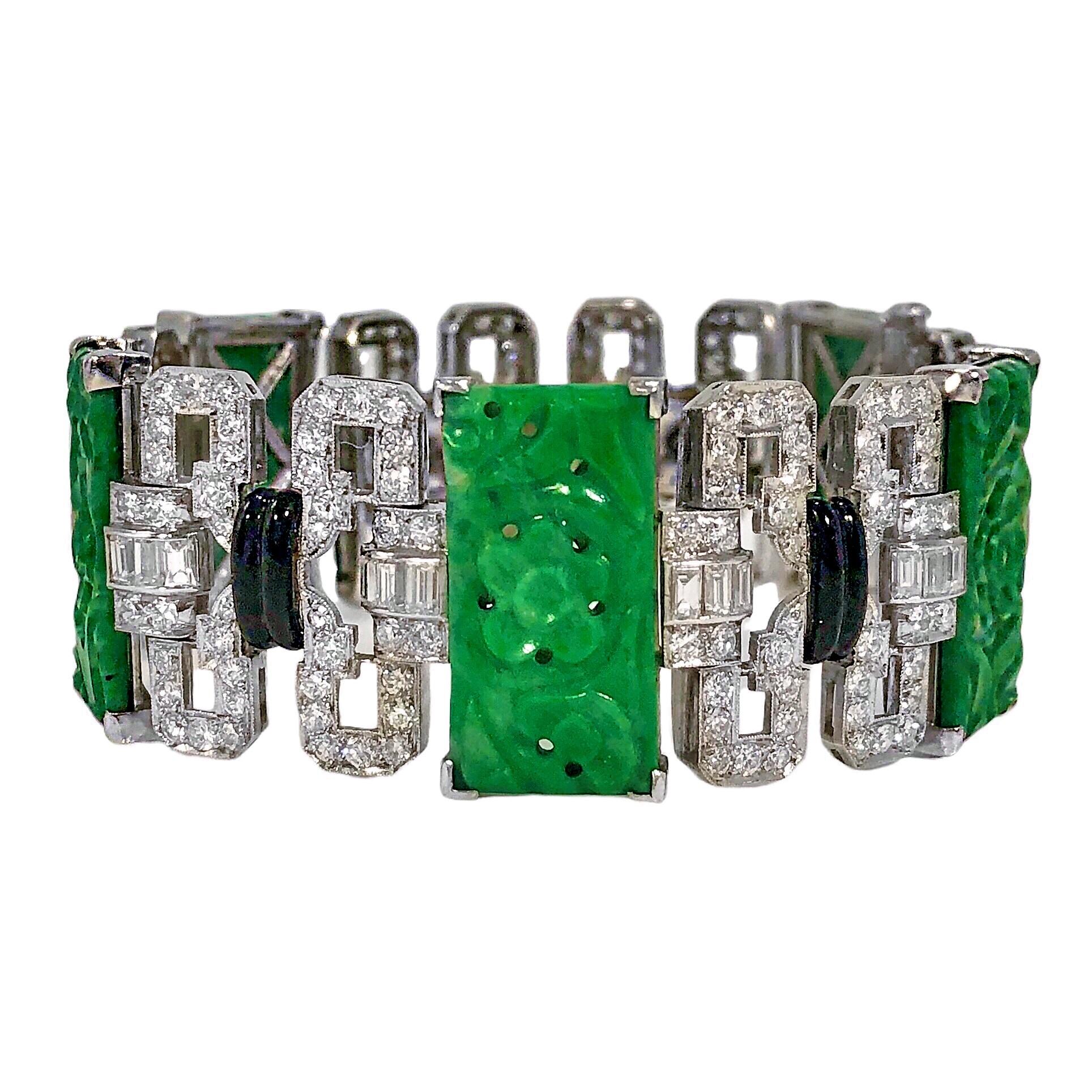 This original Art-Deco period platinum bracelet features five carved and pierced Jadeite Jade panels separated by diamond links that are punctuated with black enamel stations. The reverse side of each jade panel is extensively hand engraved. The