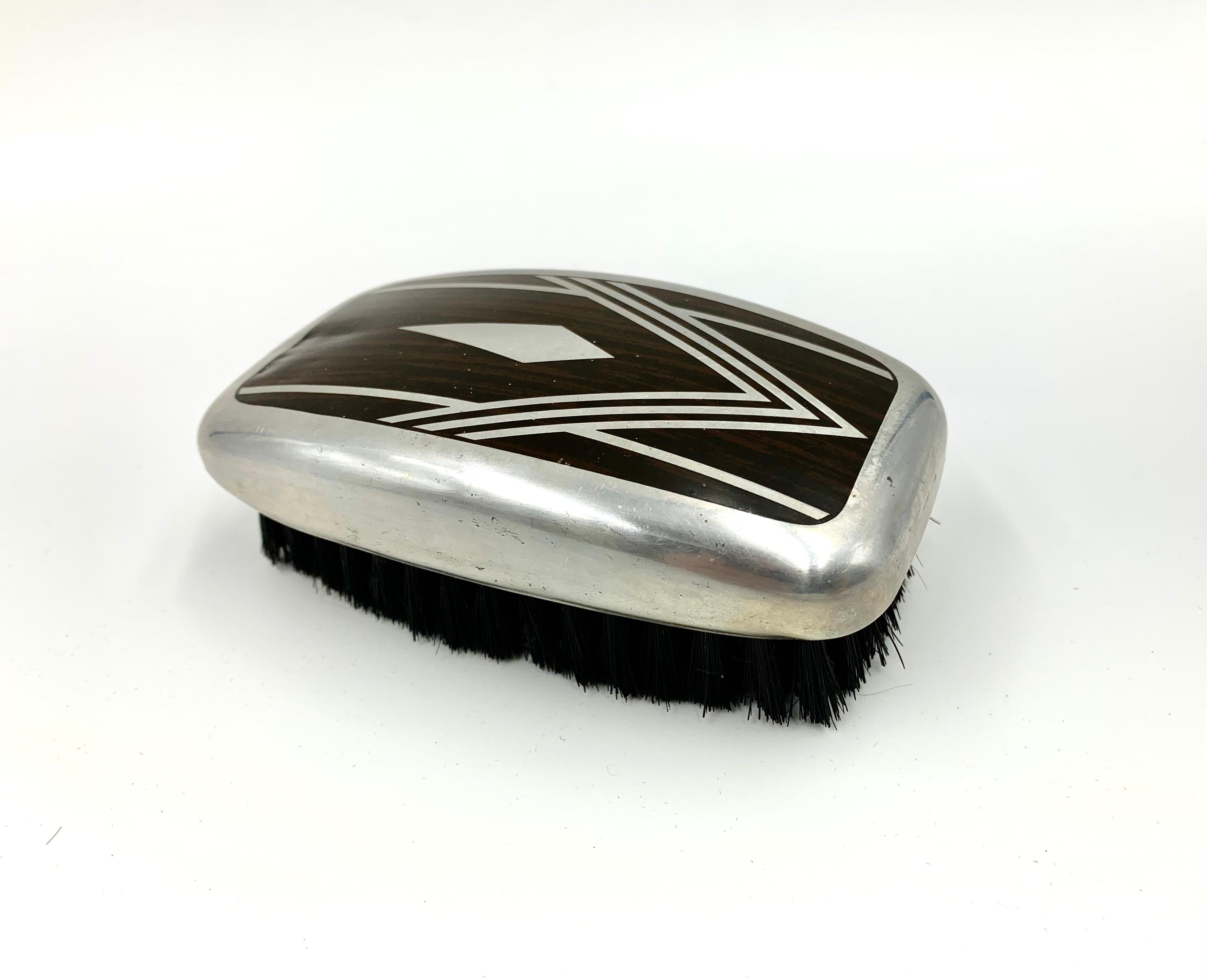 Fabulous Art Deco aluminum inlaid Macassar Ebony faux bois natural boar's hair bristle grooming brush in the manner of Emile-Jacques Rhulmann.
1920s
This stylish accessory would have been used by a gentleman in the early 20th Century. Diamond