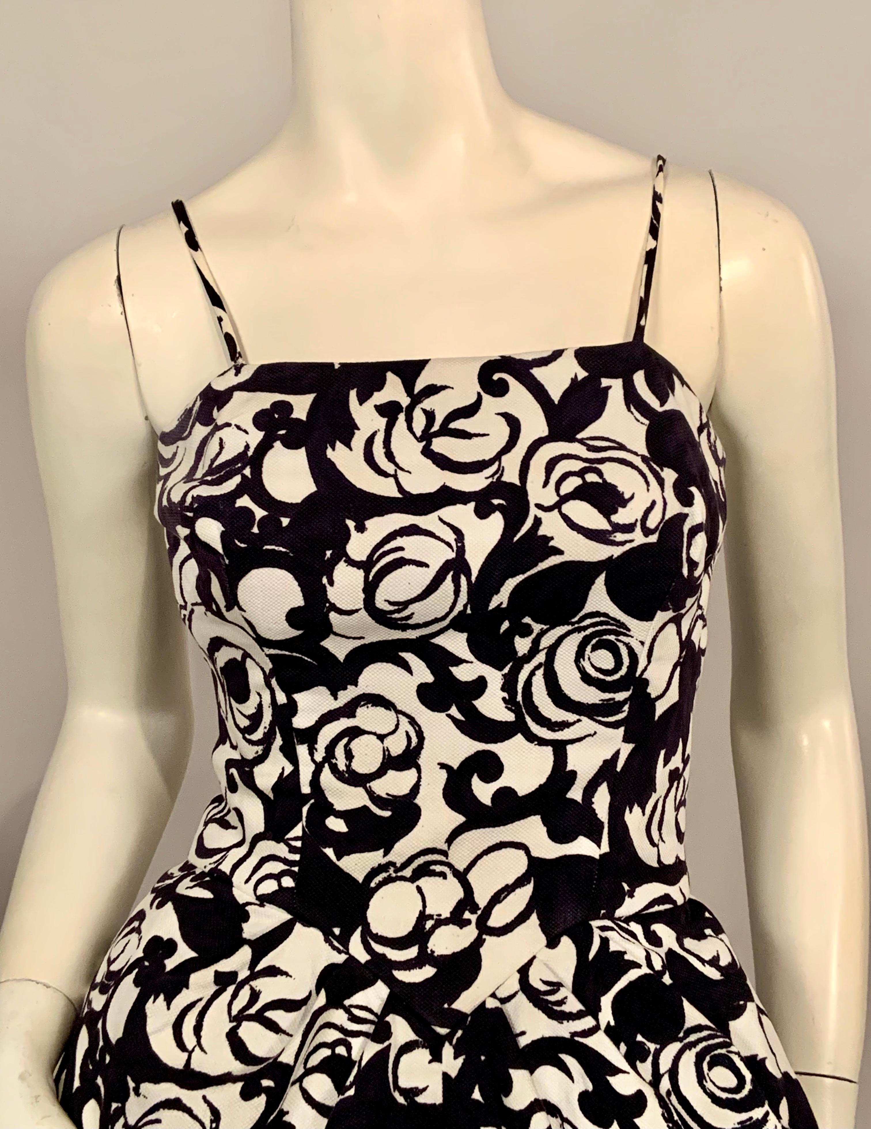 This charming black and white floral print cotton pique summer evening dress will definitely get you noticed.   The dress has spaghetti straps, a fitted bodice with a V shaped, corset style seam above soft pleats in the full skirt.  The skirt gets