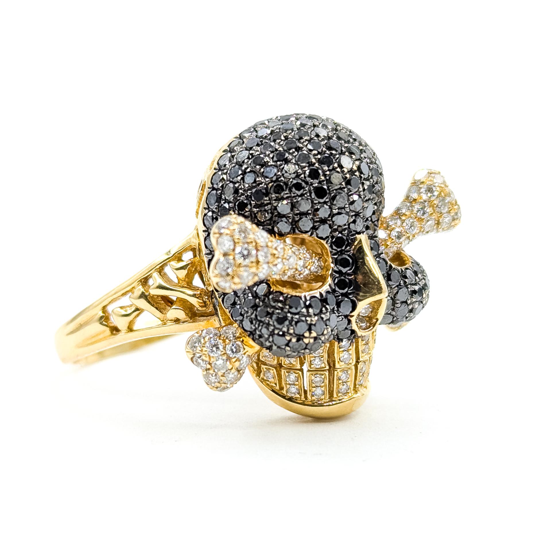 Questo audace anello è realizzato in oro giallo 14k e sfoggia un sorprendente disegno di teschio e ossa incrociate. Con una combinazione di diamanti neri e bianchi a taglio brillante per un totale di circa 3,38 carati, il contrasto crea una