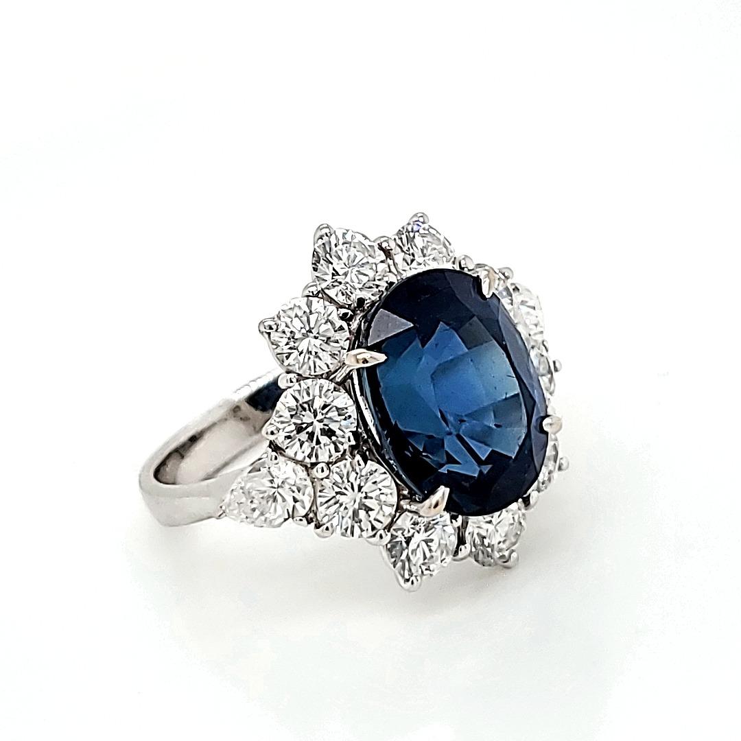 Bague de fiançailles en saphir bleu en platine avec un excellent entourage de diamants. 

Exemplaire et extraordinaire sont les deux mots qui décrivent cette bague unique et magnifique composée d'un saphir de 7,85 cts d'une couleur intense et d'une