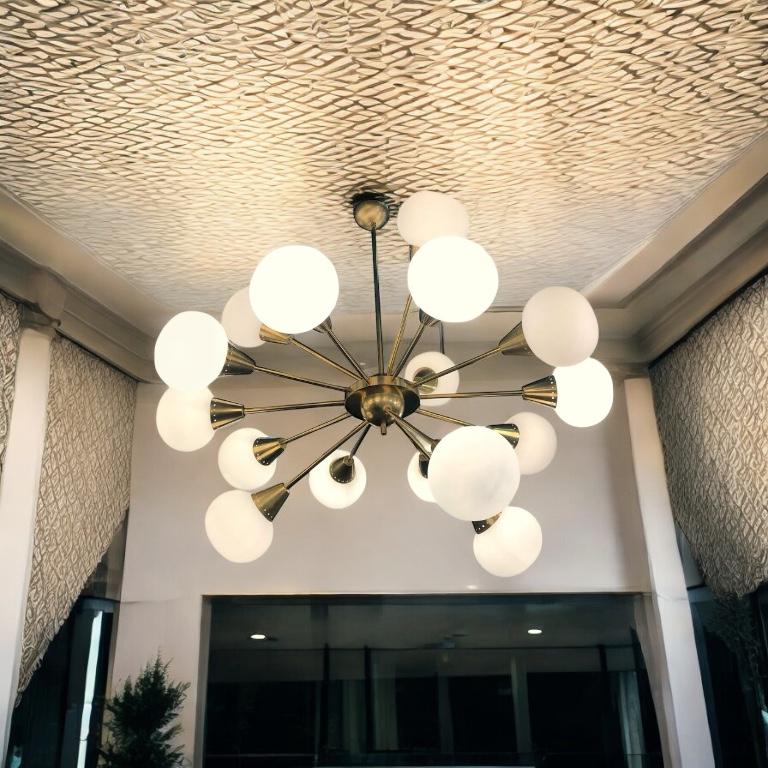 Extraordinary Italian midcentury brass and 16 opaline sphere Murano glass large Sputnik chandelier.
Available also a pair. The brass height is customizable.
16 E27 light bulbs.
This light fixture can be disassembled and the glasses individually