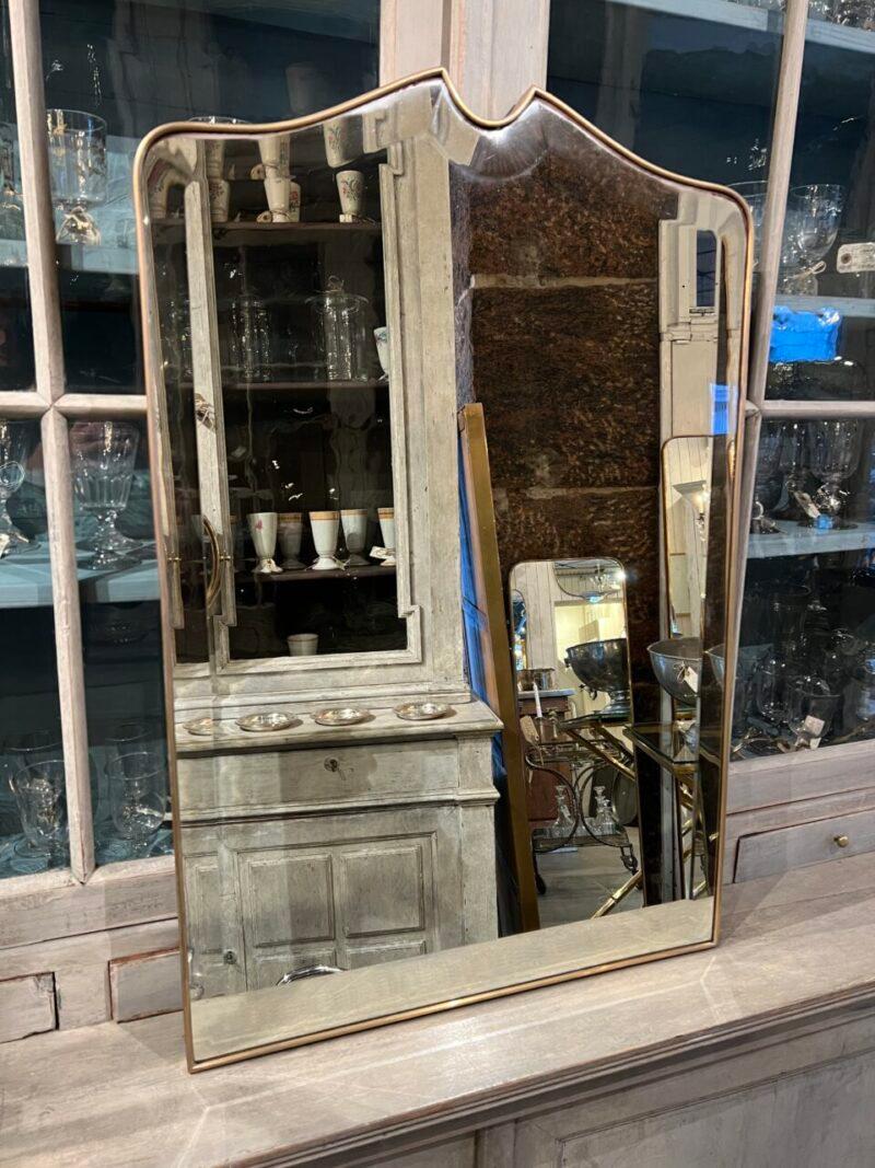 Striking Italian wall mirror with a brass frame, dating from the middle of the last century, which has a stunning and imaginative design at the top. Note the wide frame/profile and bevelled mirror glass

Stylistically related to Giò Ponti’s brass
