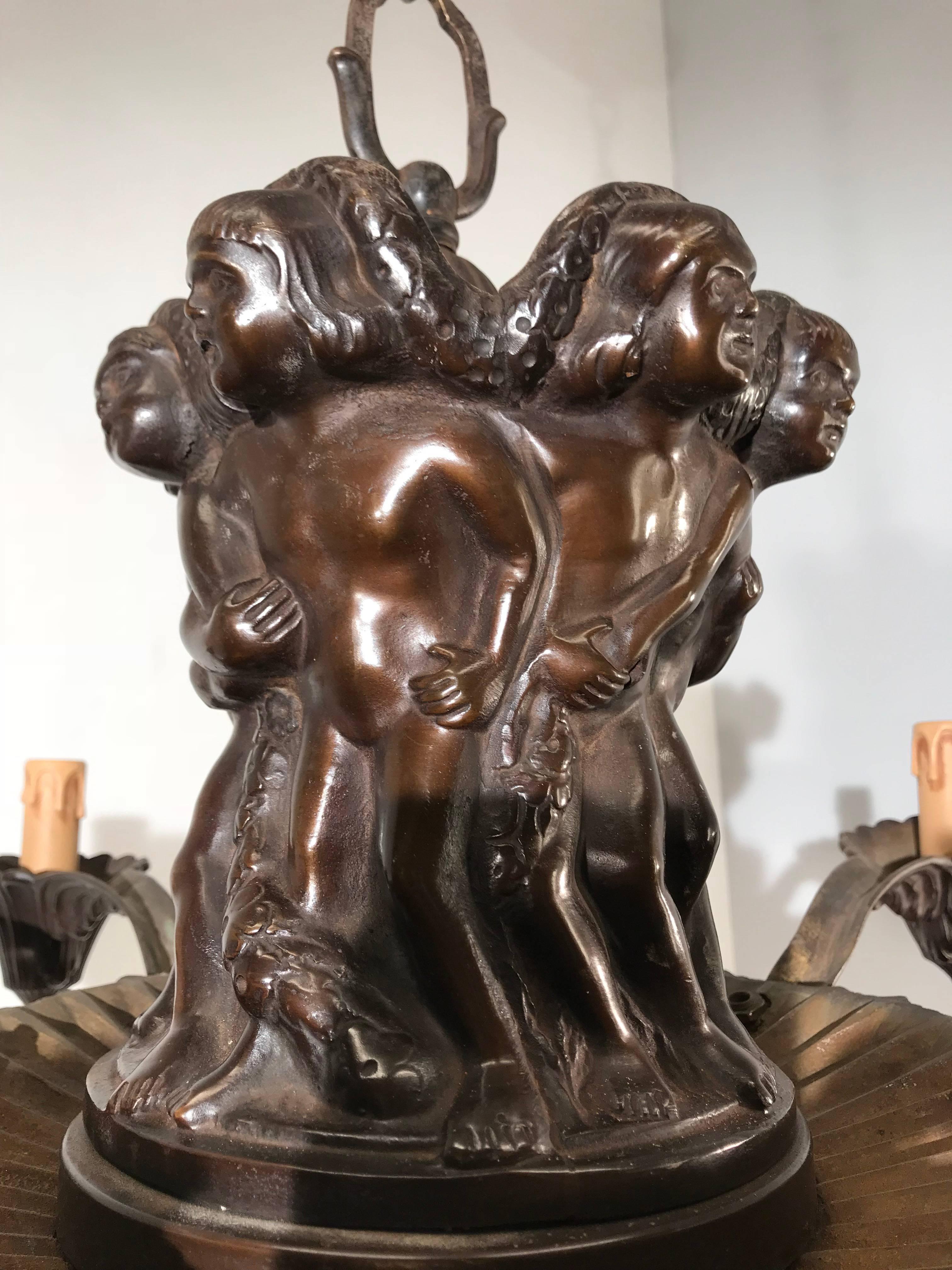 Early 1900s rare and sculptural chandelier.

This antique and heavy quality chandelier comes with a mounted putti group sculpture and we think the underlying meaning is of all times. The bronze sculpture atop this work of lighting art shows us six