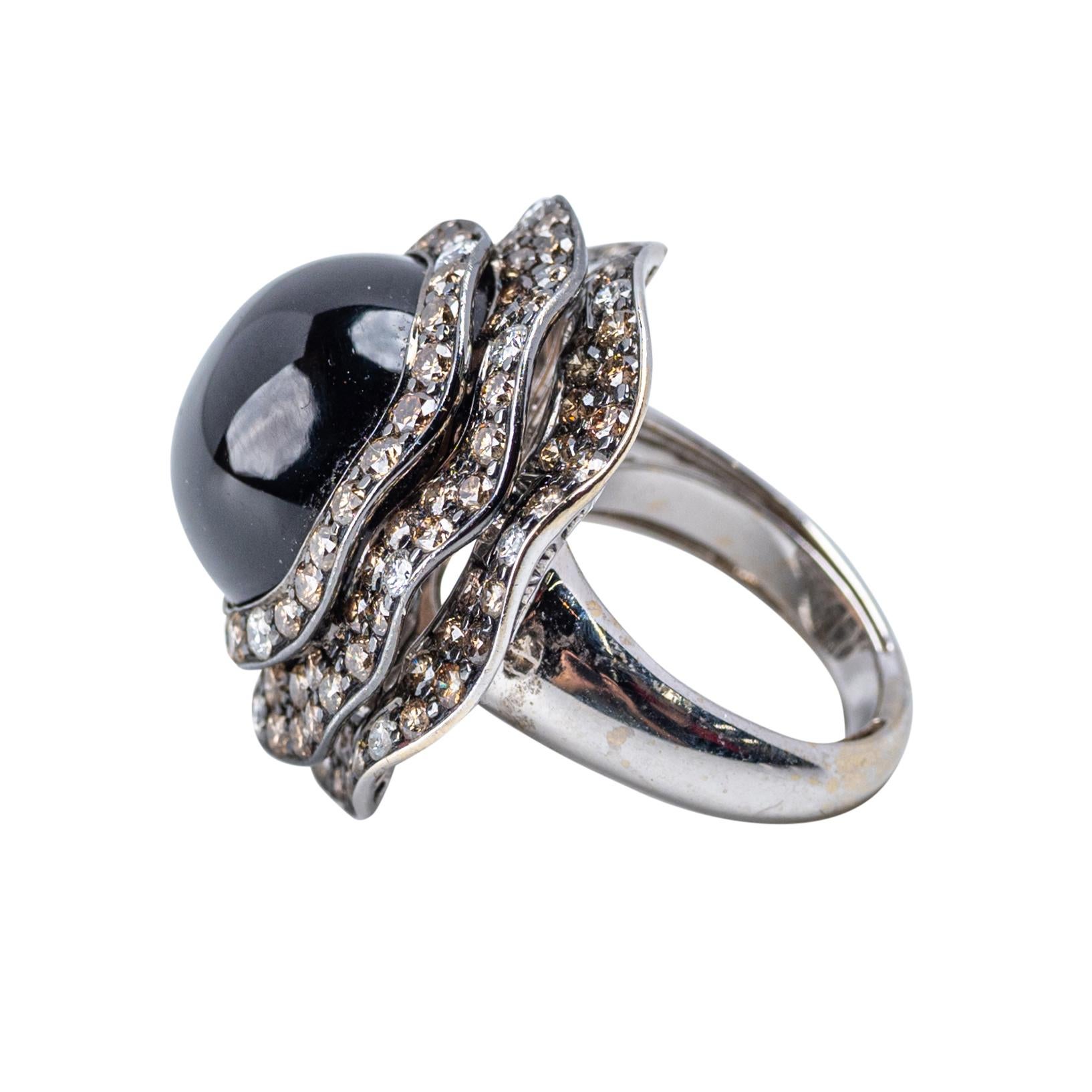 Auffälliger Cabochon-Ring aus schwarzem Quarz und Diamant in 18 Karat Weißgold

Ein beeindruckender Ring mit einem leuchtenden, gewölbten Cabochon aus schwarzem Quarz von ca. 20 Karat, der von schimmernden Diamanten im Brillantschliff in