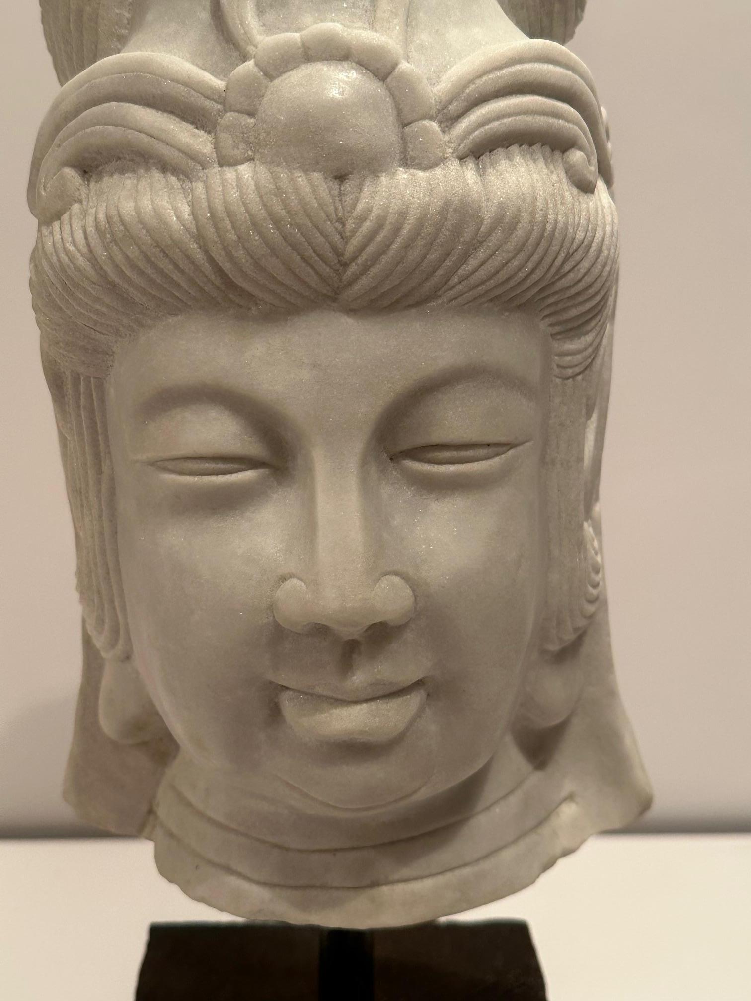 Beautiful bust carved in marble of an ethereal Quan Yin goddess figure with lovely peaceful expression.  On black custom stand.