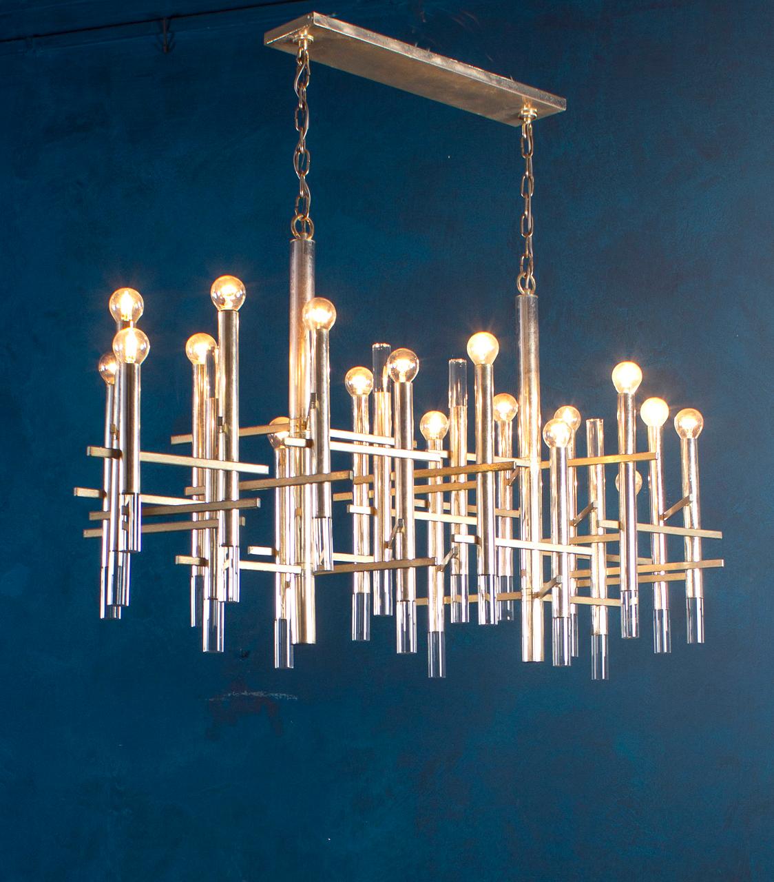Una impresionante lámpara de araña Sciolari de cromo y níquel cepillado, perteneciente a la serie inspirada en un viaje de Gaetano Sciolari a Nueva York.
La araña está compuesta por 18 tubos que irradian una luz impactante.
La estructura está