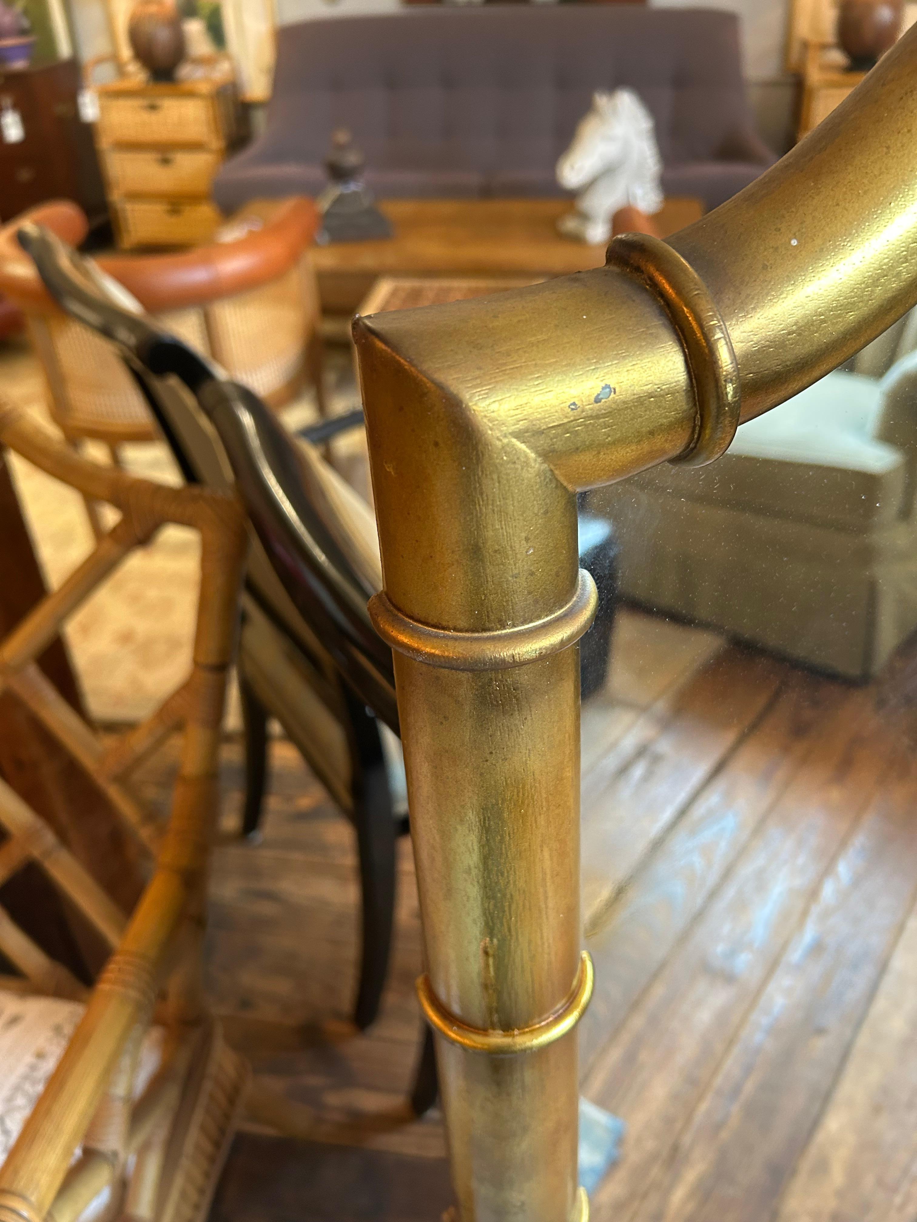 Elegante specchio verticale in finto bambù dorato con piano curvo.