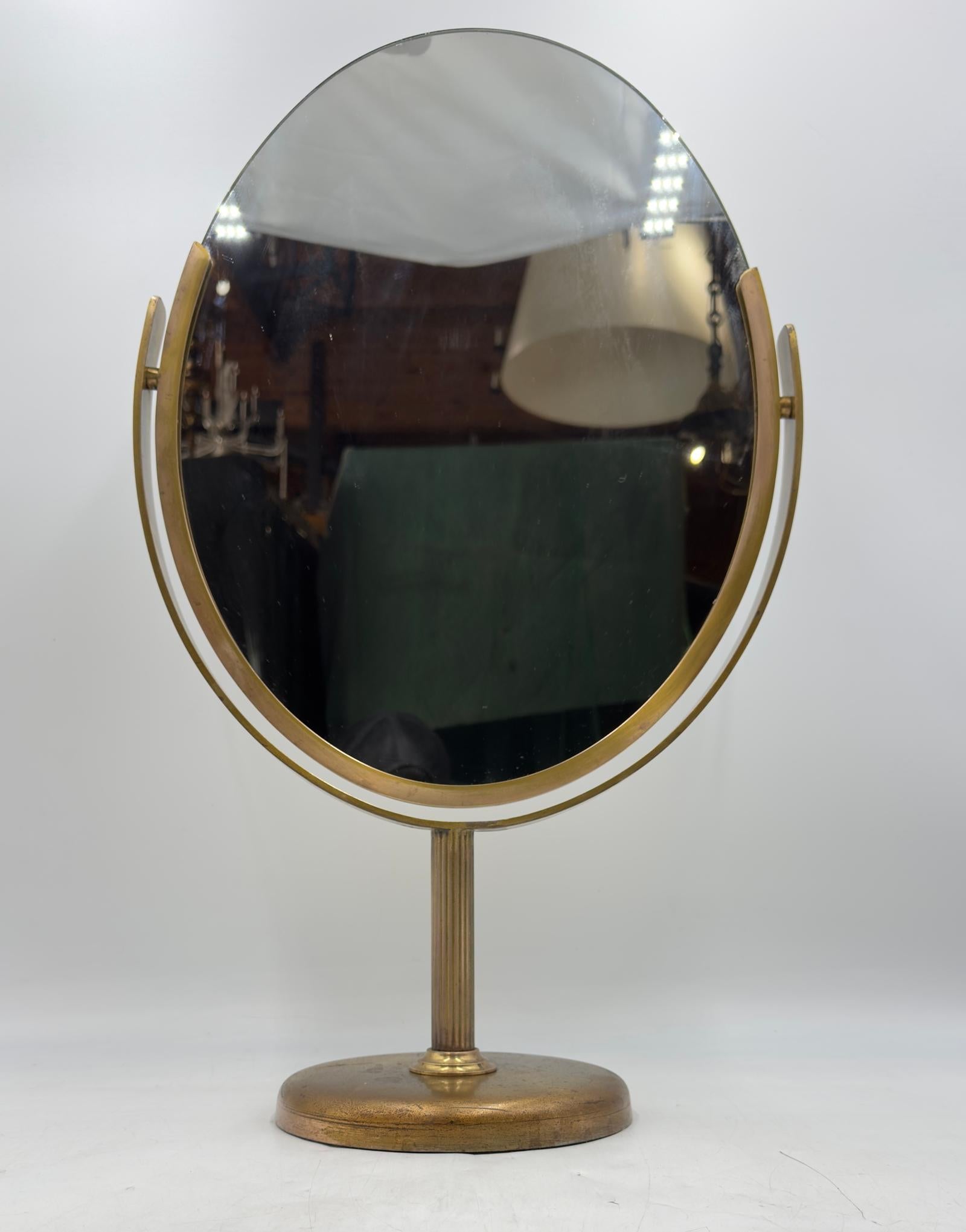 Eleganter und zeitloser ovaler Tischspiegel, entworfen von Charles Hollis Jones, hergestellt in Los Angeles, Kalifornien in den 1970er Jahren. Dieses Stück verfügt über einen doppelseitigen Spiegel ohne Vergrößerung, der mit patiniertem Messing