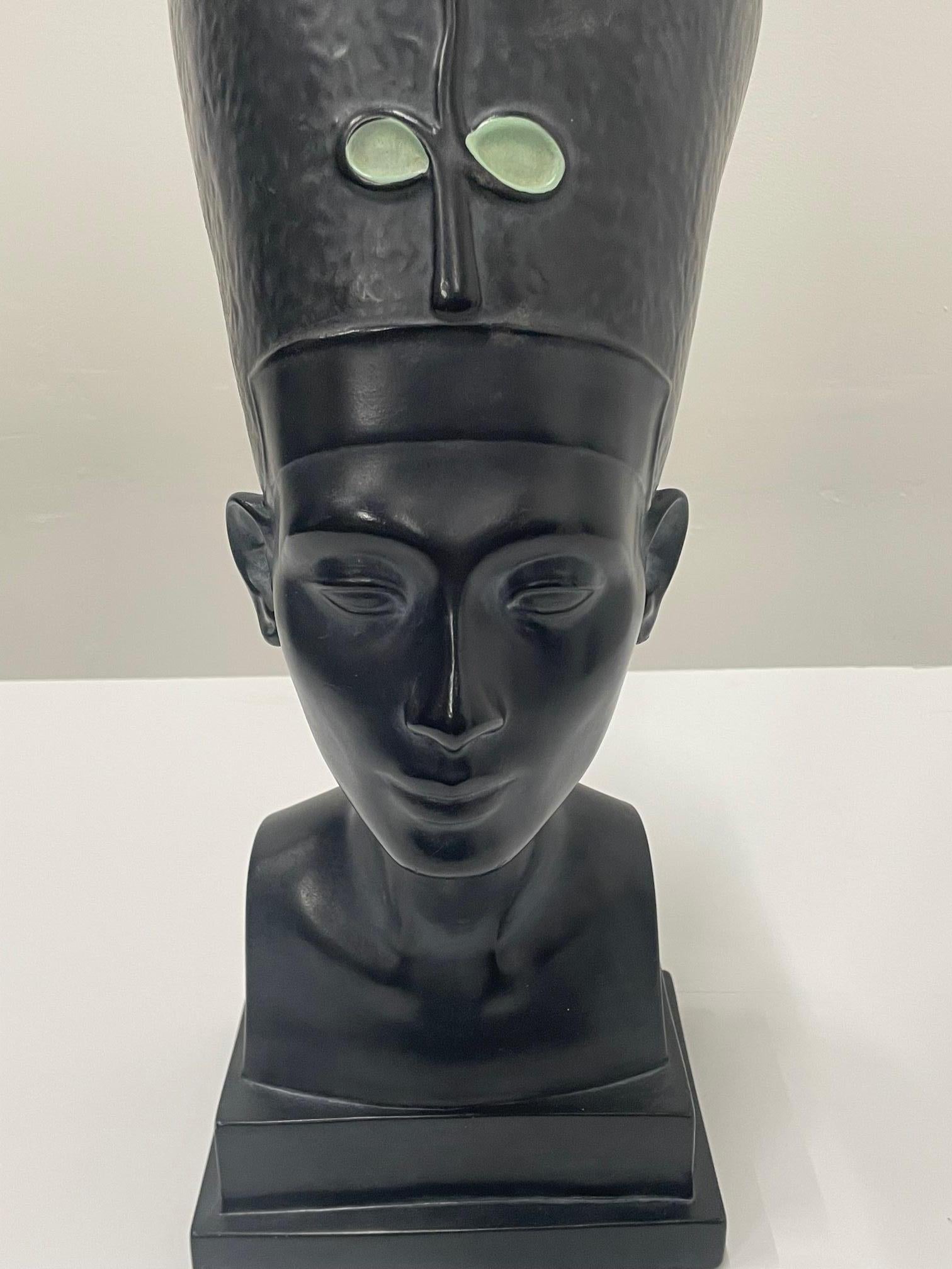 A sculptural black ebonized bust of Nefertiti has a striking moody prescence.