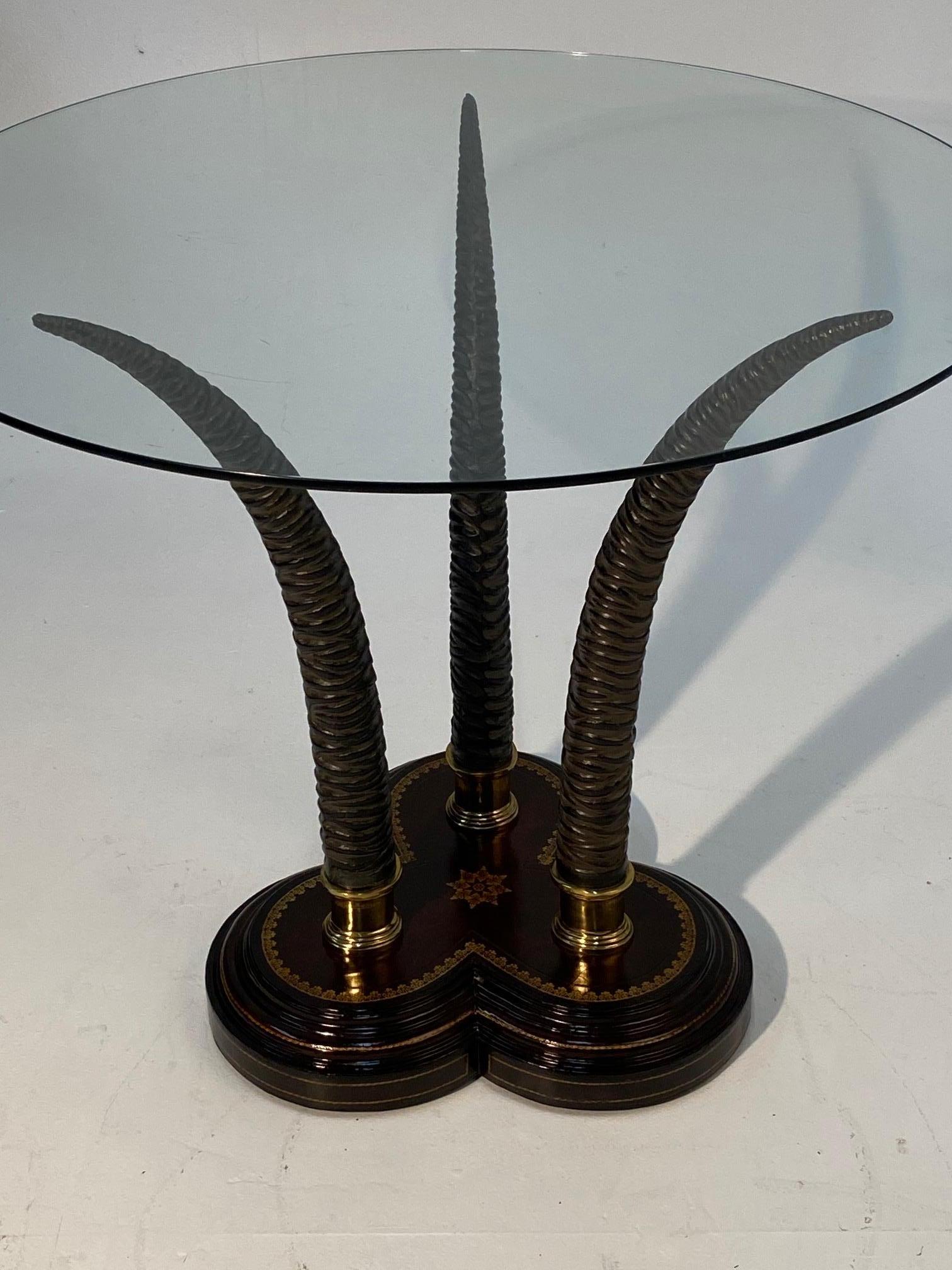 Striking center table having a fabulous tripod faux antler base with shamrock shaped tooled leather stand and round glass top.
Scalloped base is 18 x 18
23 diameter horn base
Glass is 3/8 thick.