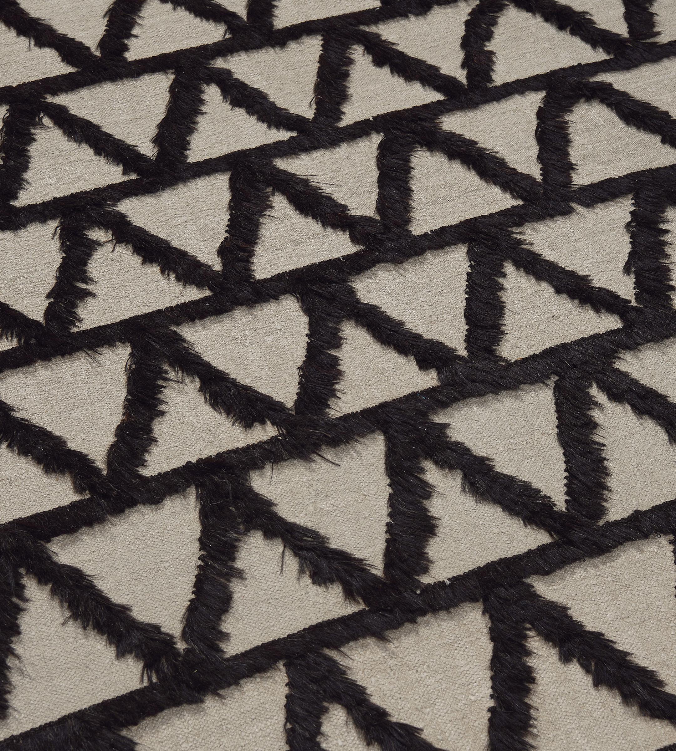 This vintage Turkish rug from the 70s has an ivory field with nine horizontal bands of bold chocolate-brown zig-zag motifs formed by goat hair with a similar plain horizontal stripe above and below.