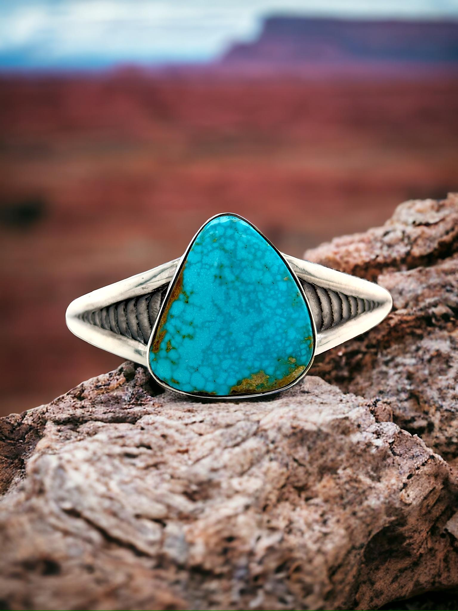 With this alluring Sterling Silver Cuff Bracelet, embrace the artistic beauty of the natural world. This one-of-a-kind piece showcases a real Kingman turquoise gemstone, renowned for its captivating matrix patterns and captivating depth of