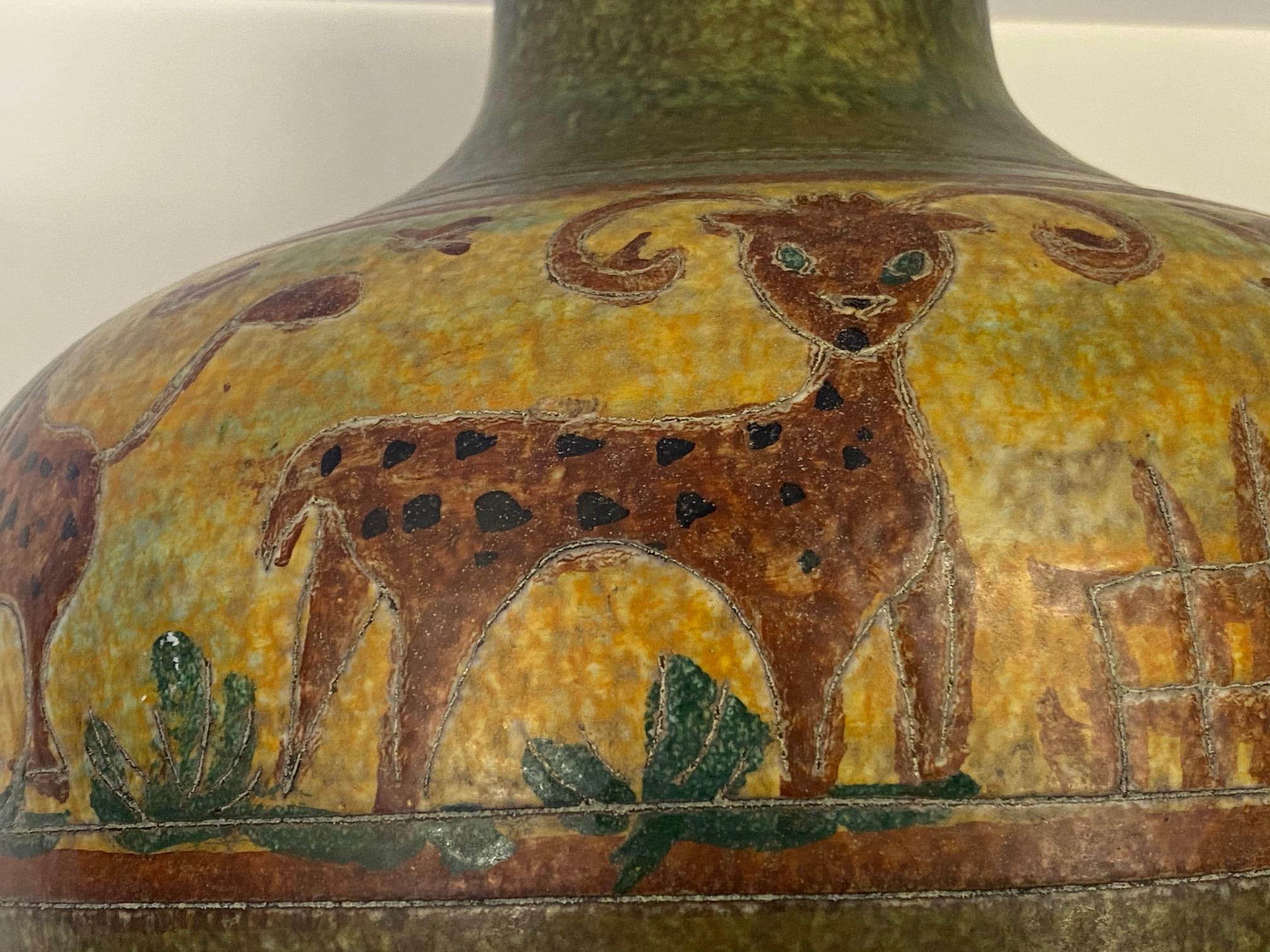 Eine auffallend große, schön dekorierte, handgedrehte italienische Keramikvase mit charmanten Tieren im naiven Stil in Erdtönen wie Grün, Braun und Gelb. Obere Öffnung 4,25