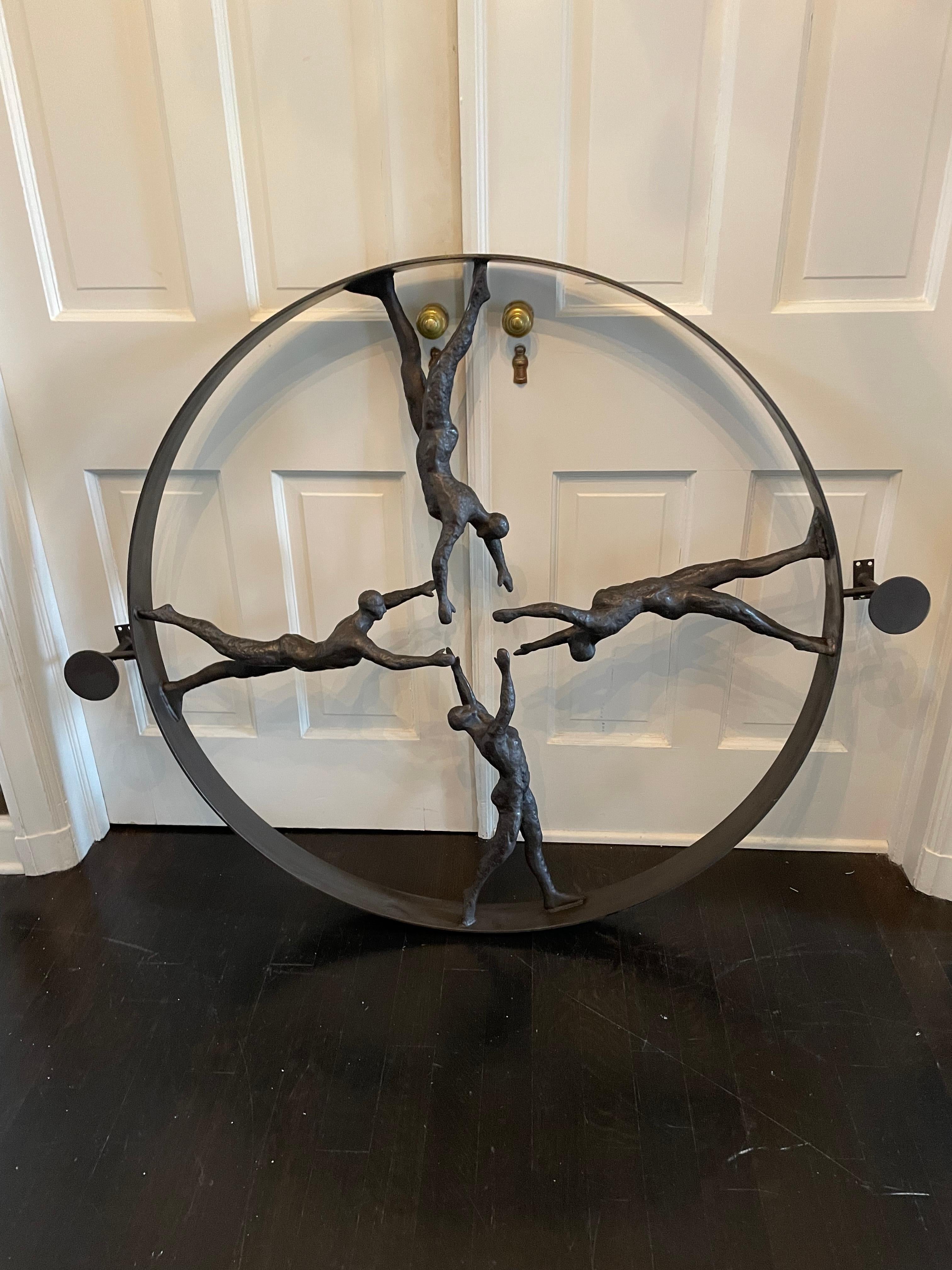 Striking and dramatic round iron wall sculpture having figures with arms extended toward the center of the circle in marvelous gestural poses. Hand forged iron.