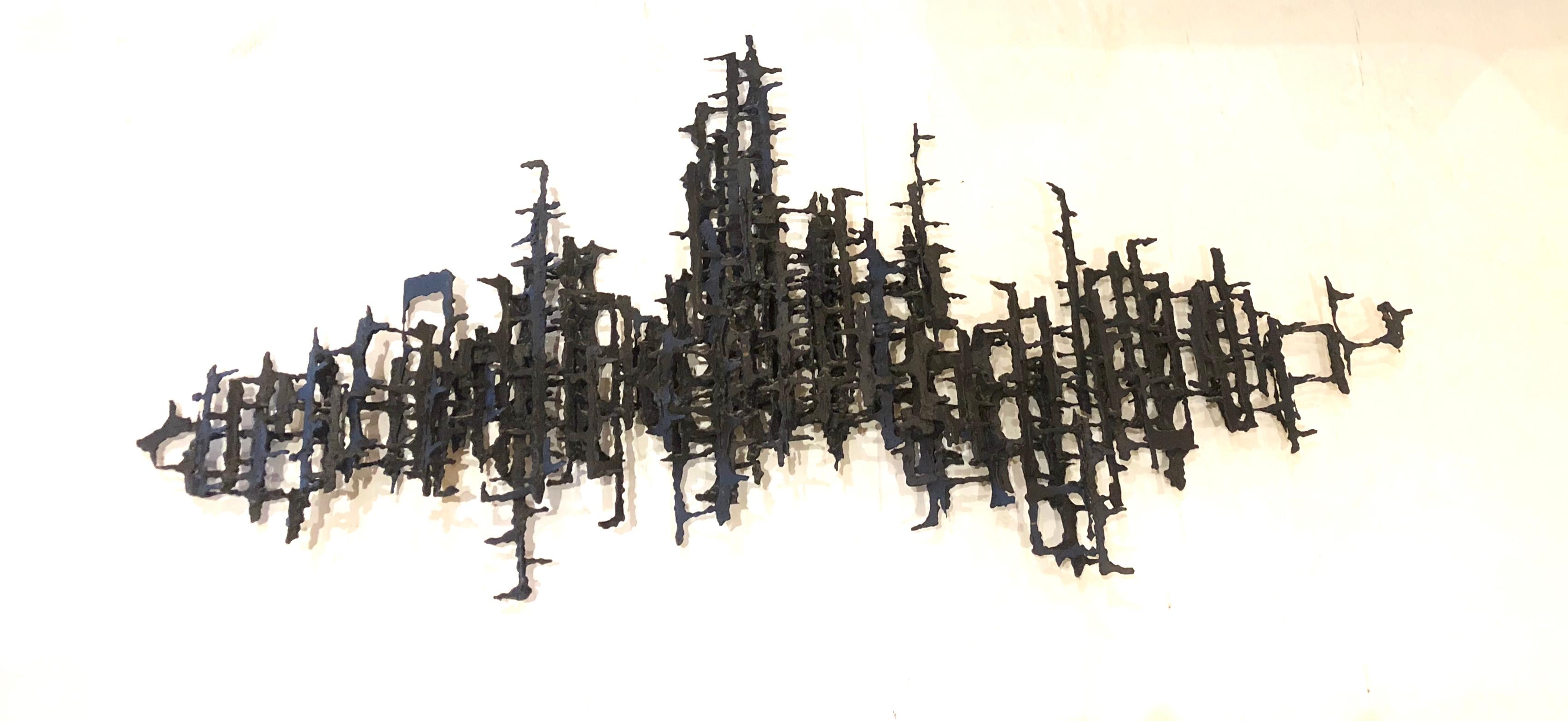 Large scale brutal torch cut iron wall sculpture signed Daniel Gluck. Often attributed to Marcello Fantoni. In black finish some light bending rust shows due to age. This piece its unsigned but we are confident that it’s his piece .