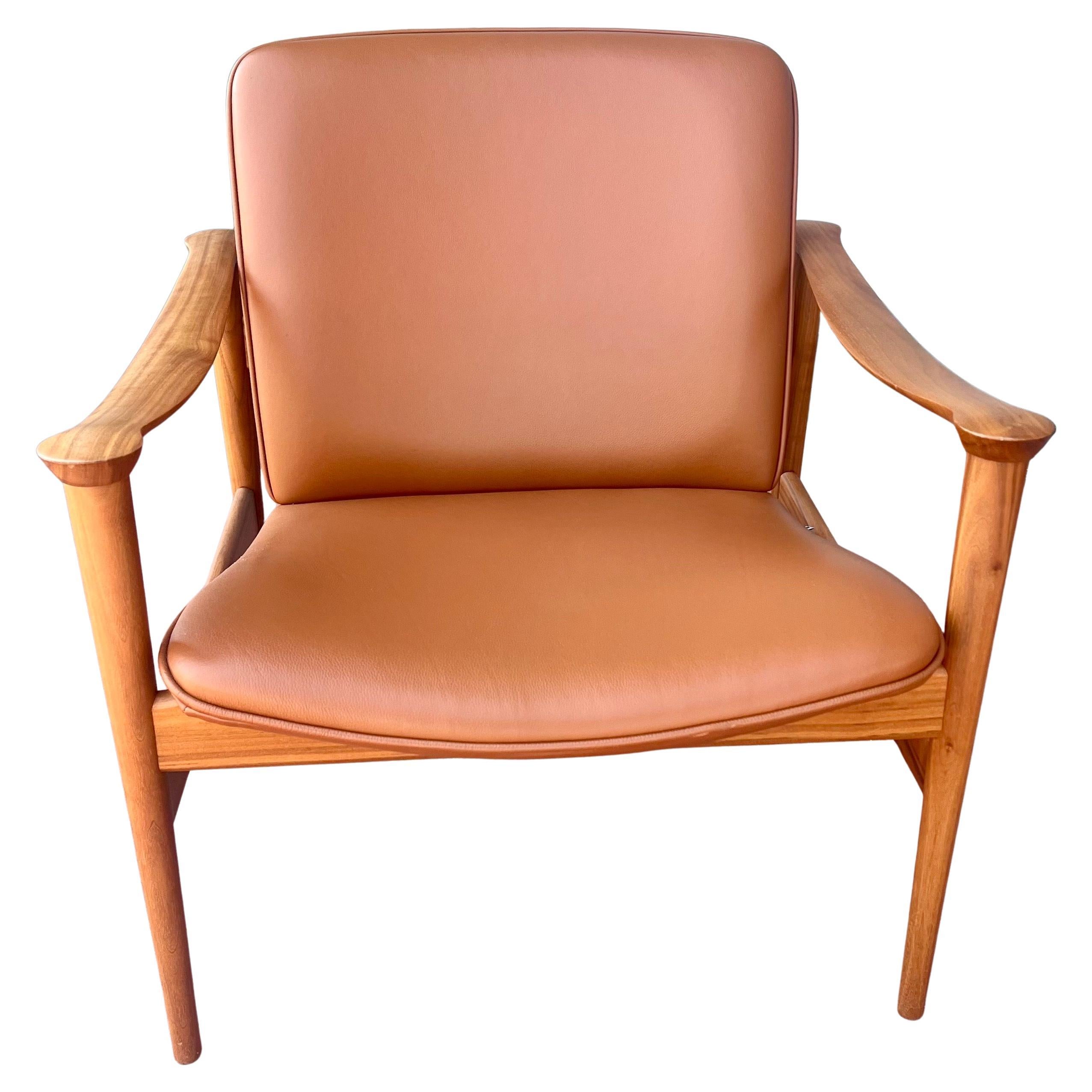 An elegant and unique beautiful Cognac leather and walnut lounge armchair was designed by Fredrik Kayser, and made in Norway the chair is in like new condition, sculpted armrests solid and sturdy very light use.
