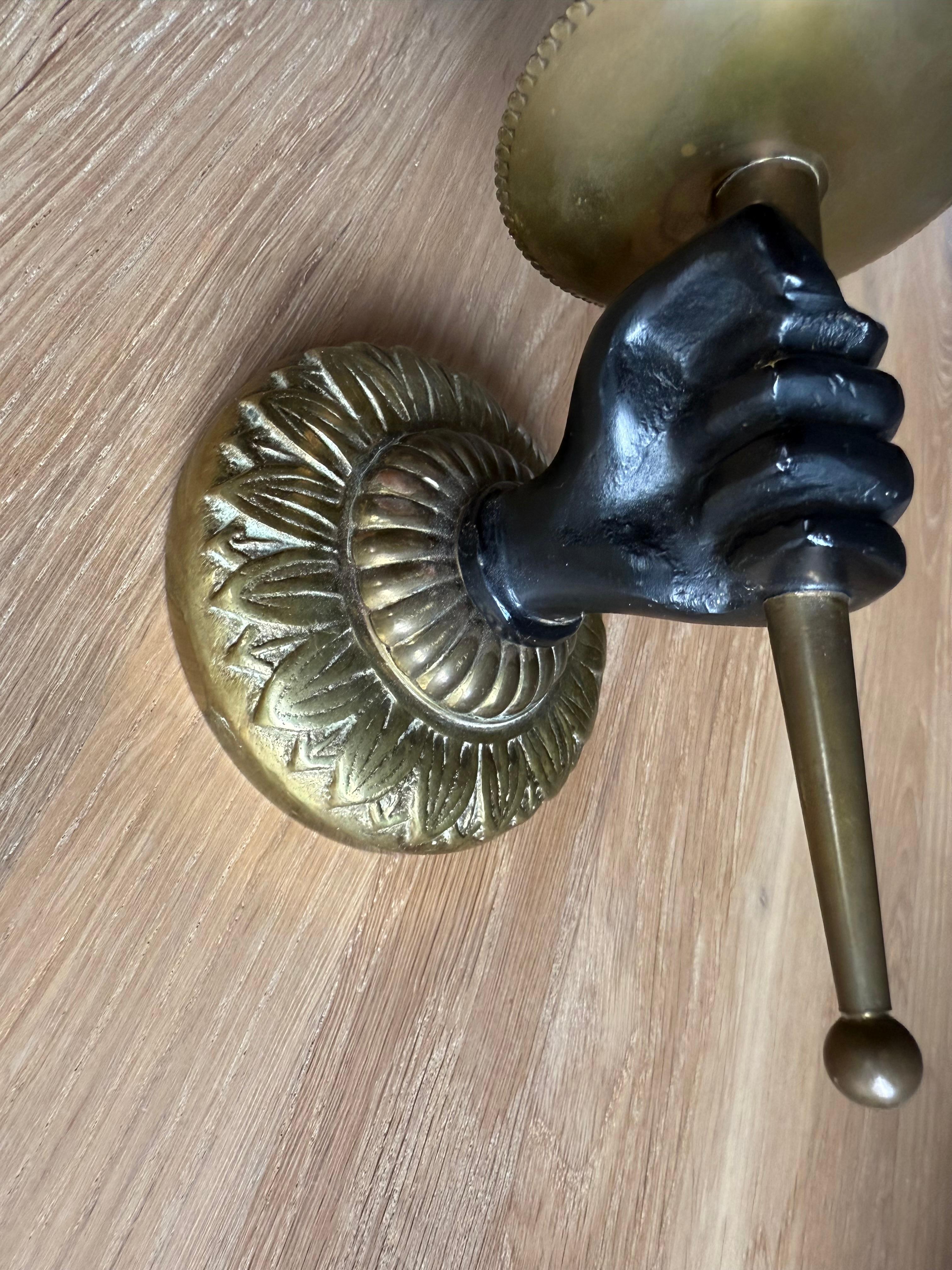 Midcentury hand - holding - torche wall lamp.

If you are looking for a small yet distinctive decorative wall sconce, look no further. This stylish and highly sought-after brass and bronze wall sconce makes the perfect accent piece, ideal for