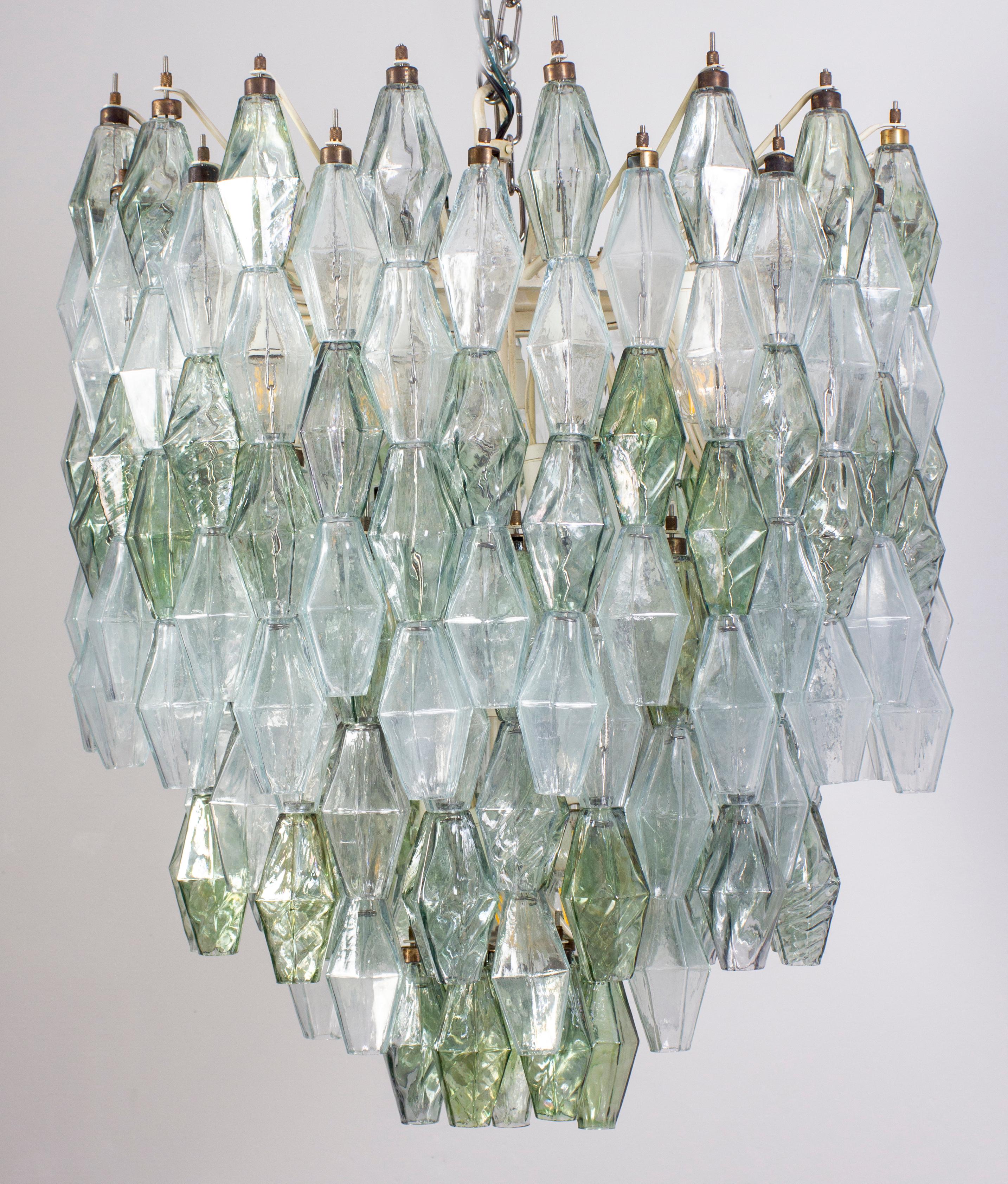 Fabulous original Polyhedral Murano glass chandelier. Rare combination green and clear colored poliedri hanging from the metal tiers at several levels.
Ivory painted round shaped frame in very good and fully original condition.
The chandelier holds