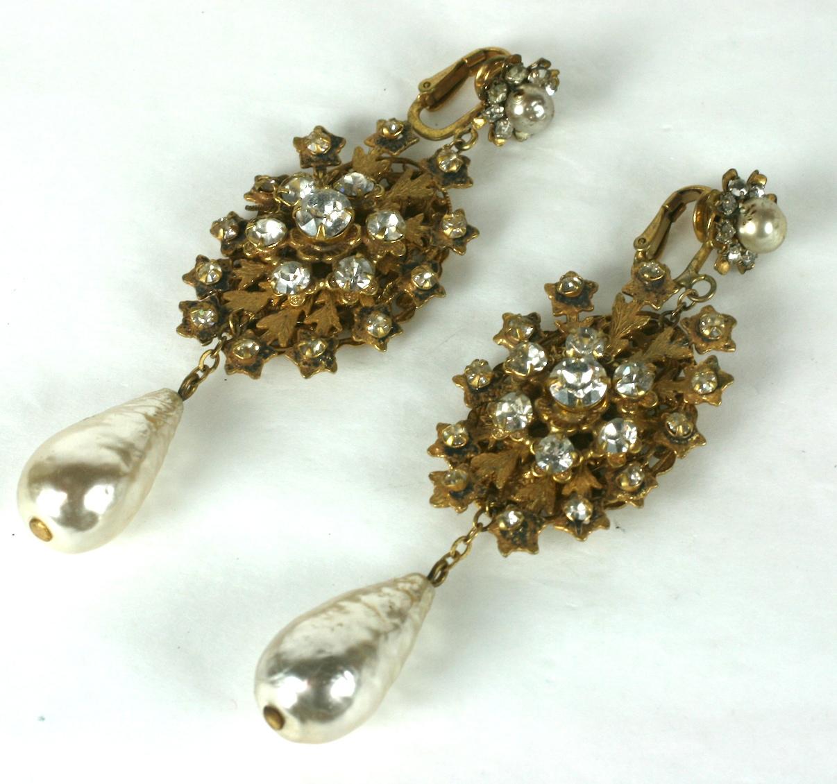 Long Miriam Haskell  signature faux baroque teardrop pearl and Russian gilt oval snowflake filigree ear clips. The oval filigree enhanced by a center crystal rhinestone flower head and set with crystal rhinestones on the surrounding spokes. 
Hand