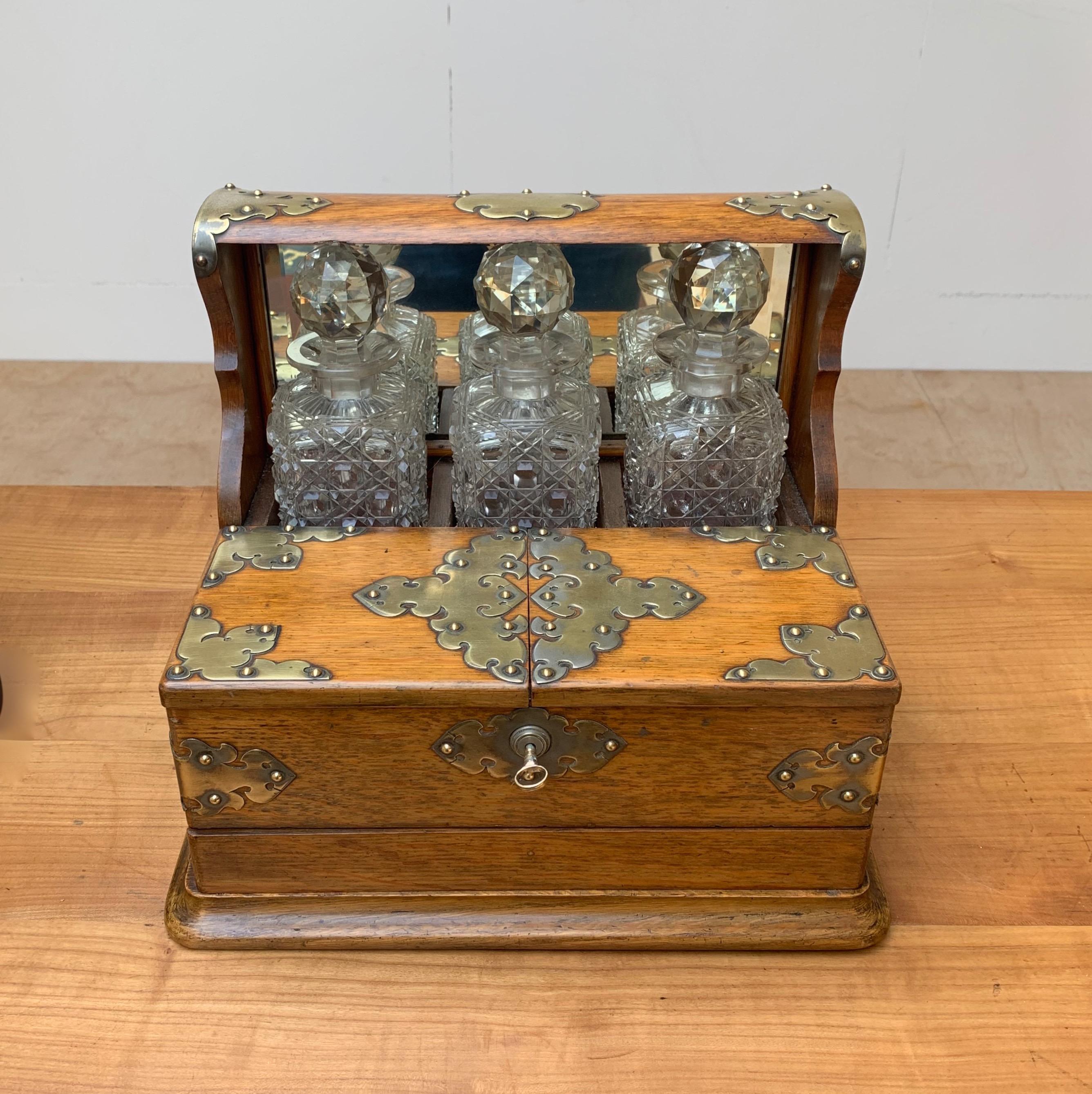 Good size and rare design, antique tantalus

This amazing condition and rare three crystal bottles holding Tantalus will look great everywhere. This hand-crafted work of beauty dates from the early 1900s and it comes with two folding lids with