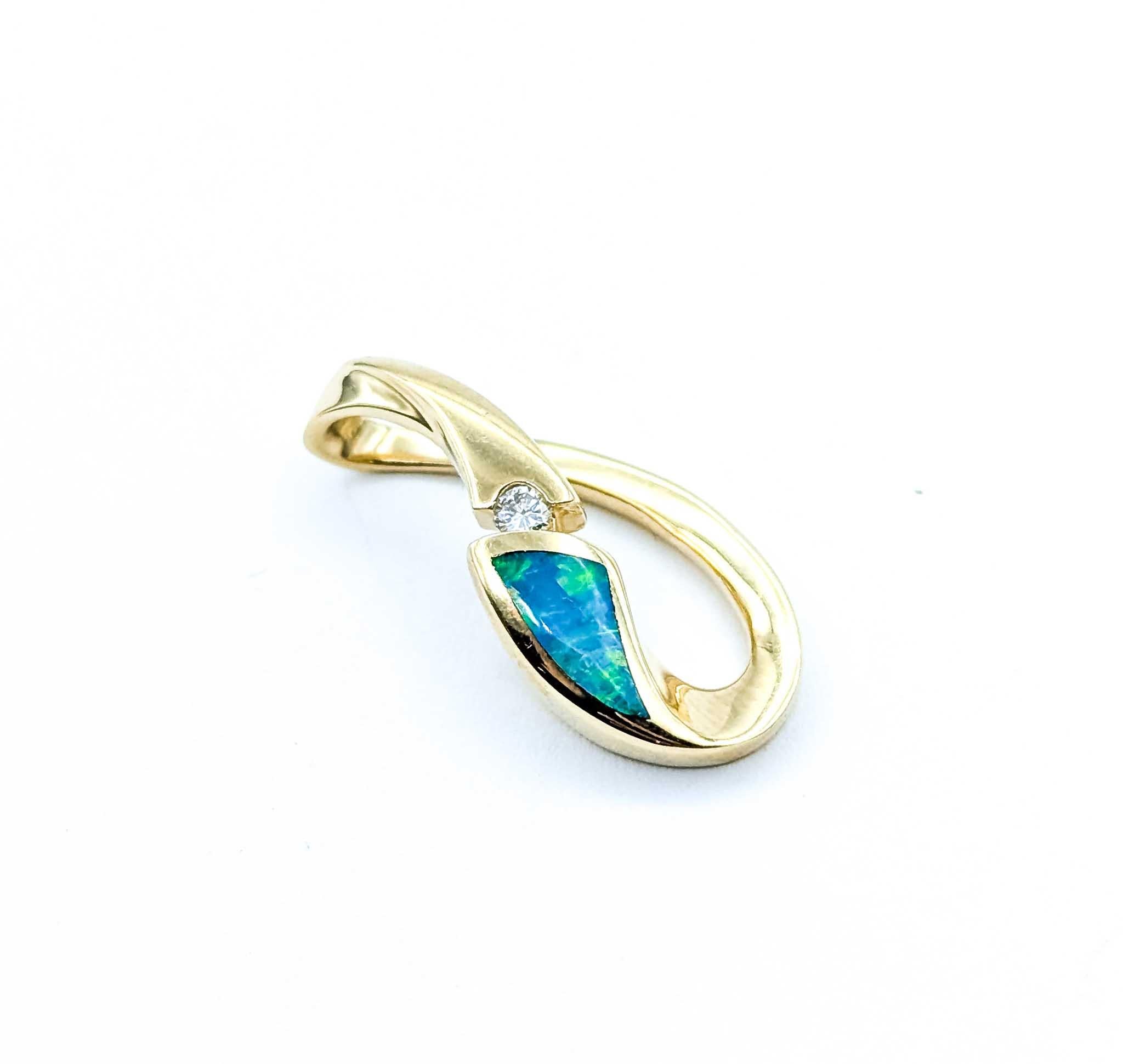 Ce pendentif contemporain en or jaune 14k est orné d'une opale vive rehaussée d'un diamant rond étincelant de 0,06 carat. L'opale présente un magnifique jeu de couleurs avec des éclats de vert et de bleu, élégamment encadré dans le design d'or