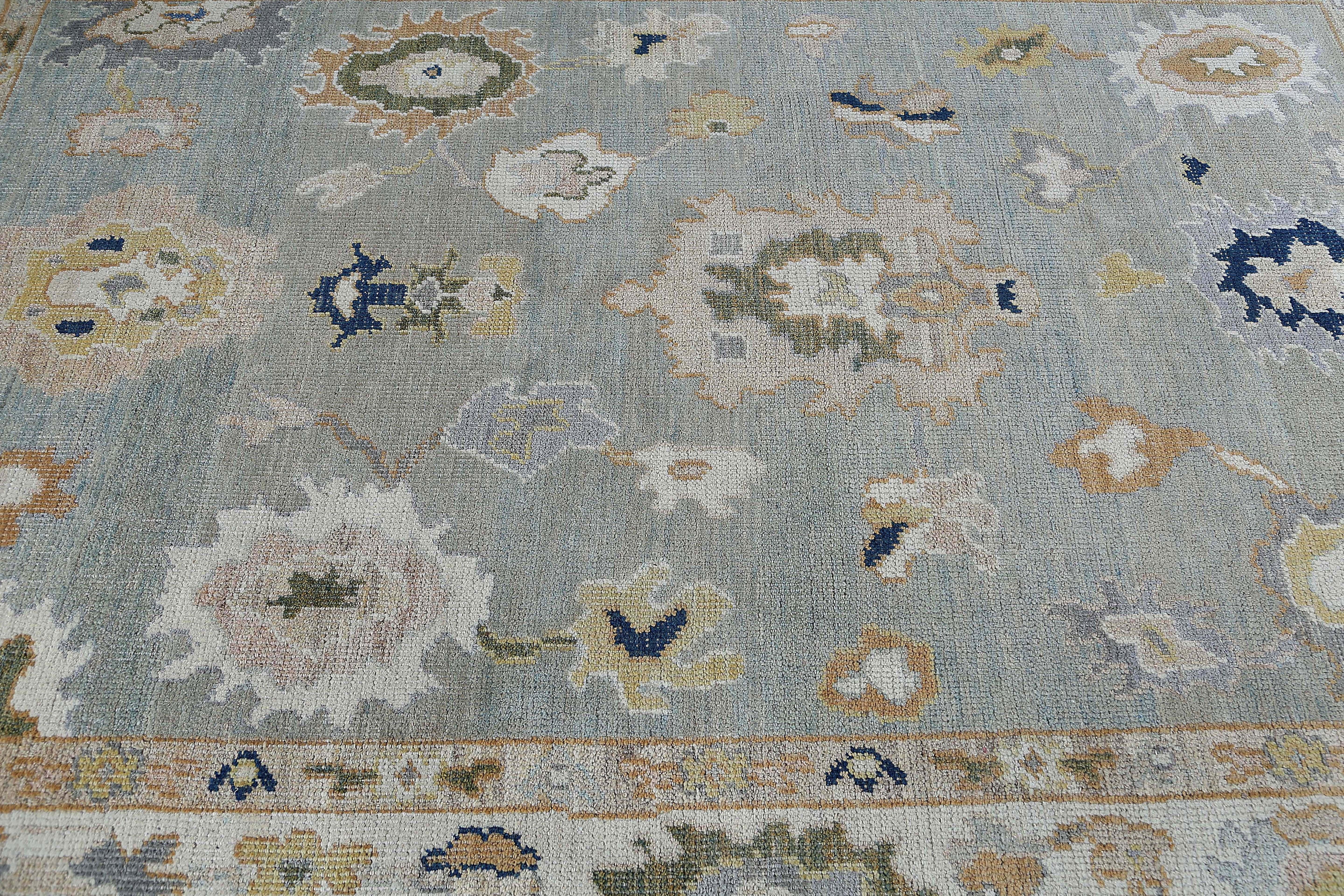 Presentamos una impresionante alfombra turca Oushak de tamaño 6'6'' x 9'1''. Esta alfombra es una auténtica obra maestra, con una llamativa combinación de tonos azules y grises que añadirá elegancia y sofisticación a cualquier habitación. El
