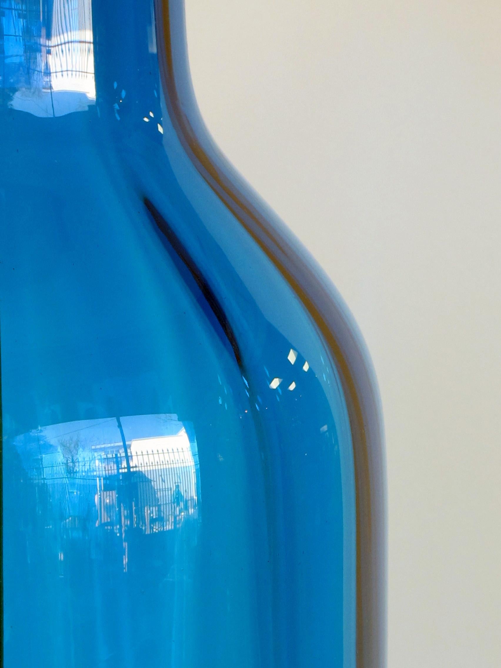 A tall and striking pair of American 1970's blue art glass bottle-form lamps; possibly by Blenko Glassworks