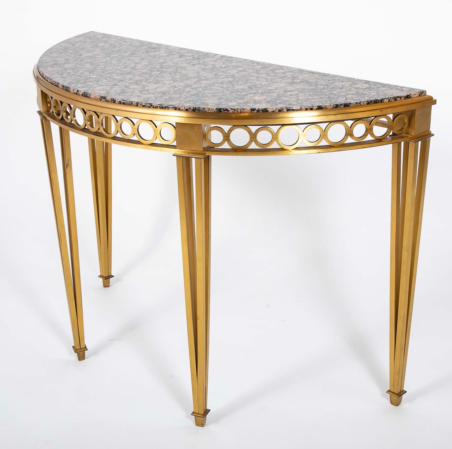 Striking pair of bronze demilune console tables with fossilized marble tops with open work aprons and legs.  