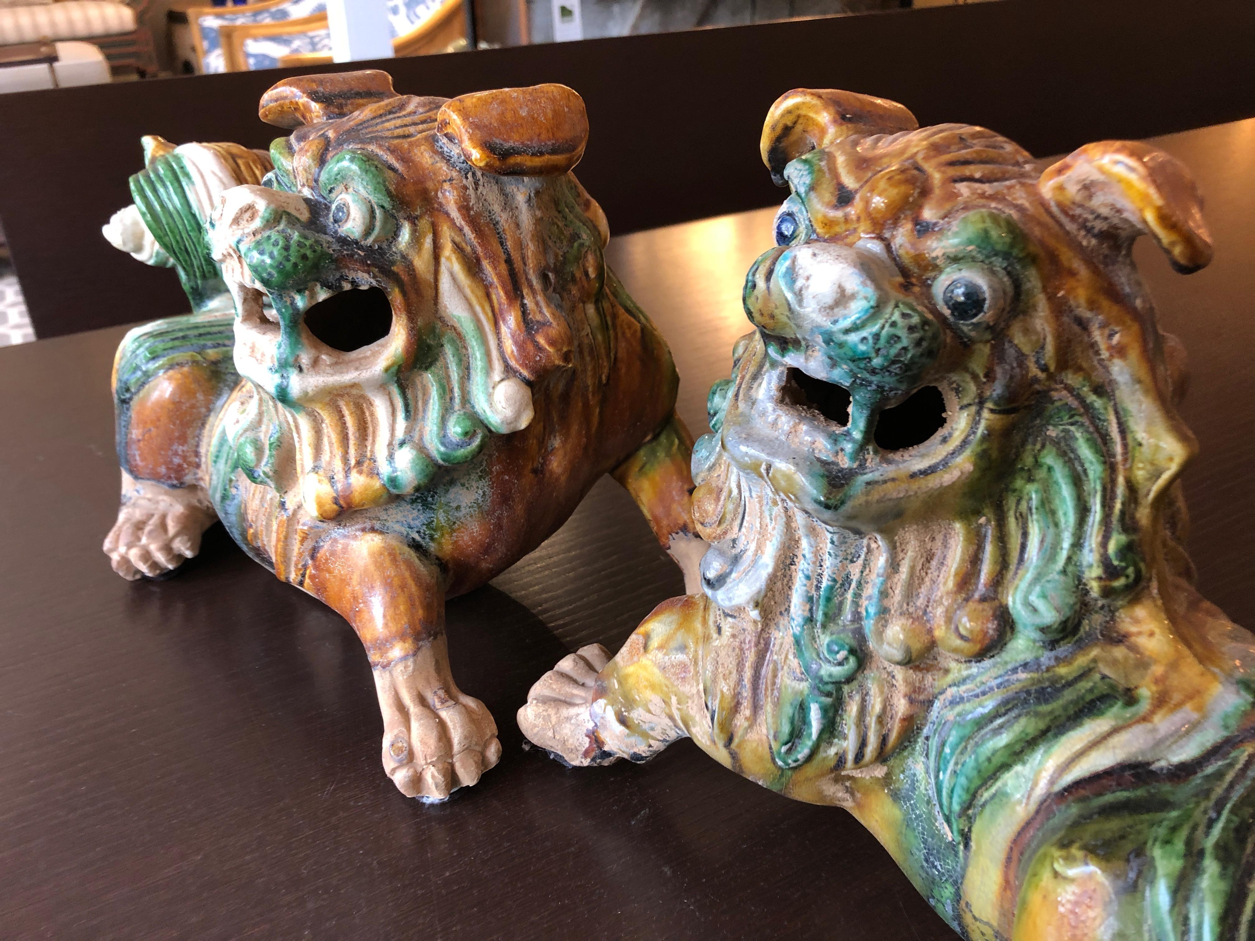 Wonderful pair of chunky earth colored ceramic foo dogs in green, ochre, gold and cream.